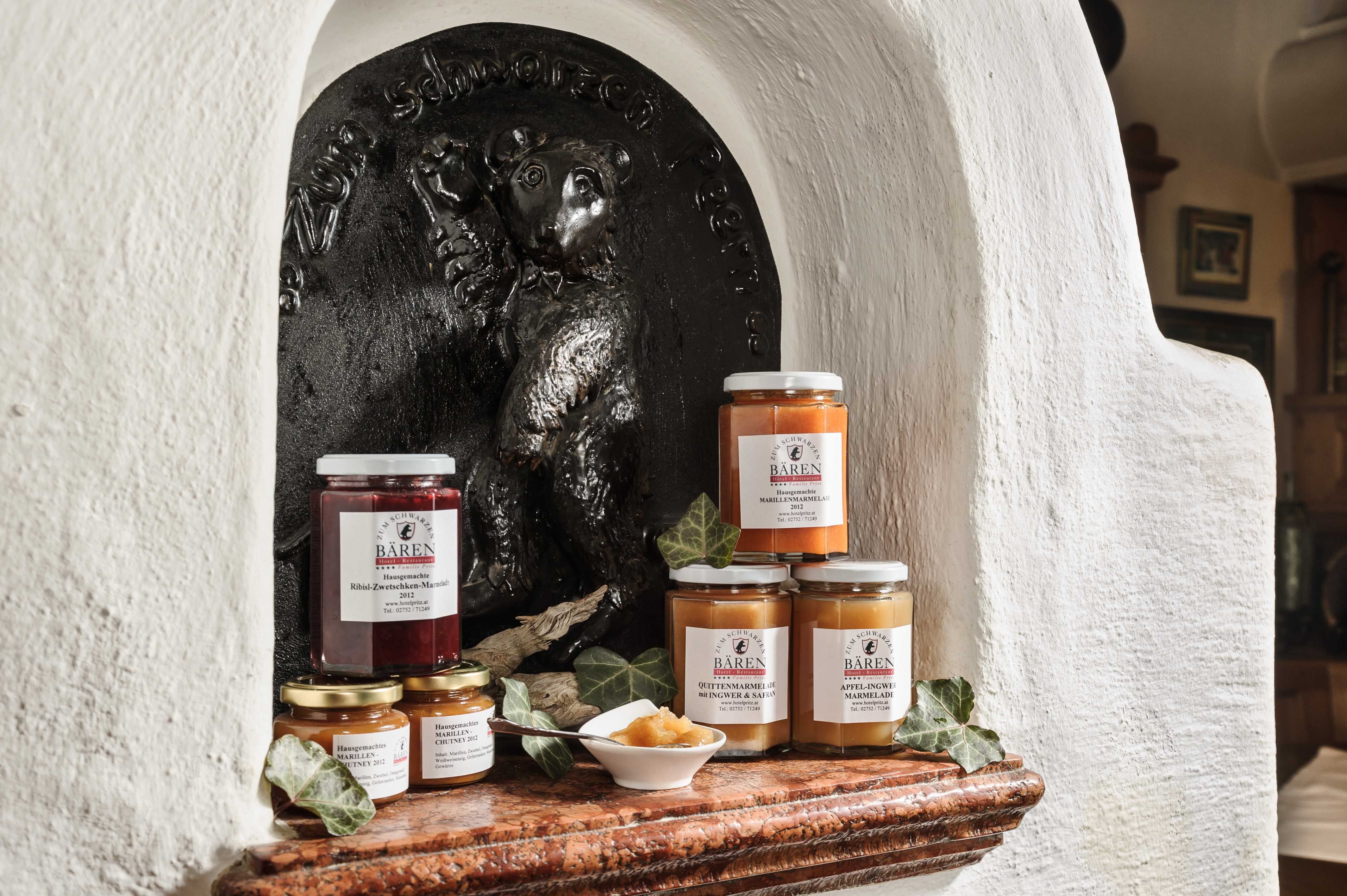 Verschiedene Marmeladengläser vor einem Bärenrelief