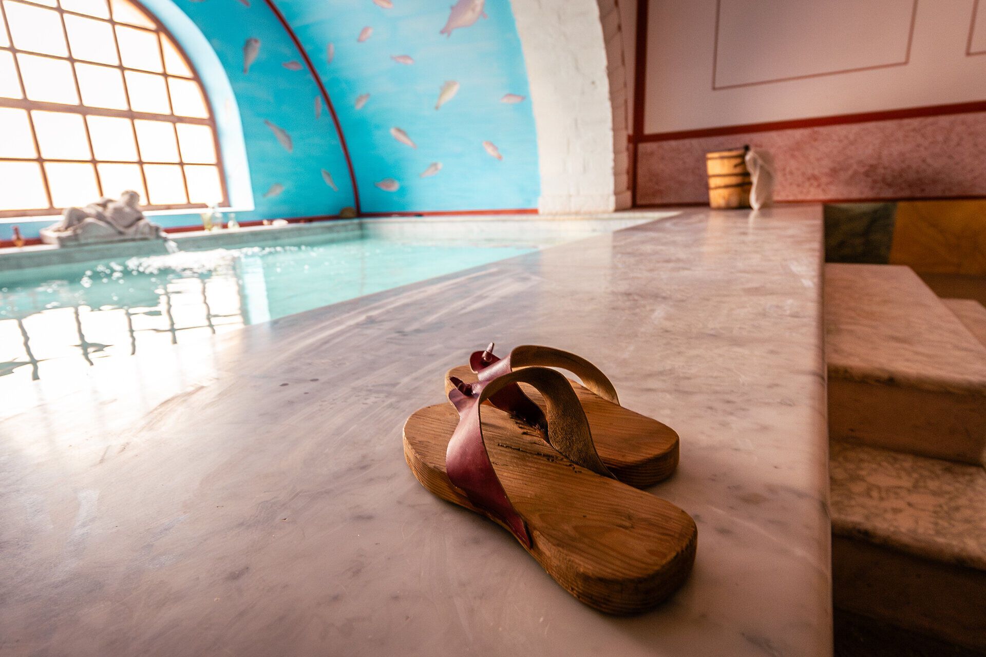 Wasserbecken in einer römischen Therme und römische Schuhe. 