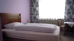 Ein einfach eingerichtetes Hotelzimmer mit Bett, Tisch und Stuhl.