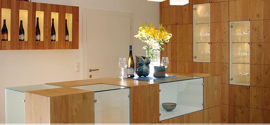 Heller Verkostungsraum mit Holztisch und Sitzgelegenheiten, ruhige Atmosphäre für Weinverkostungen in modern-rustikalem Ambiente.