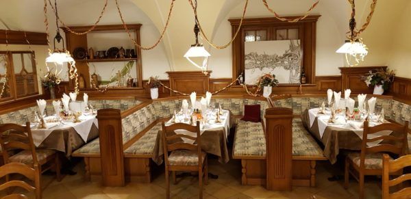 A traditionally furnished restaurant with wooden furniture and decorated tables.