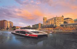 Schiff auf dem Wasser in Wien und im Hintergrund Gebäude. 