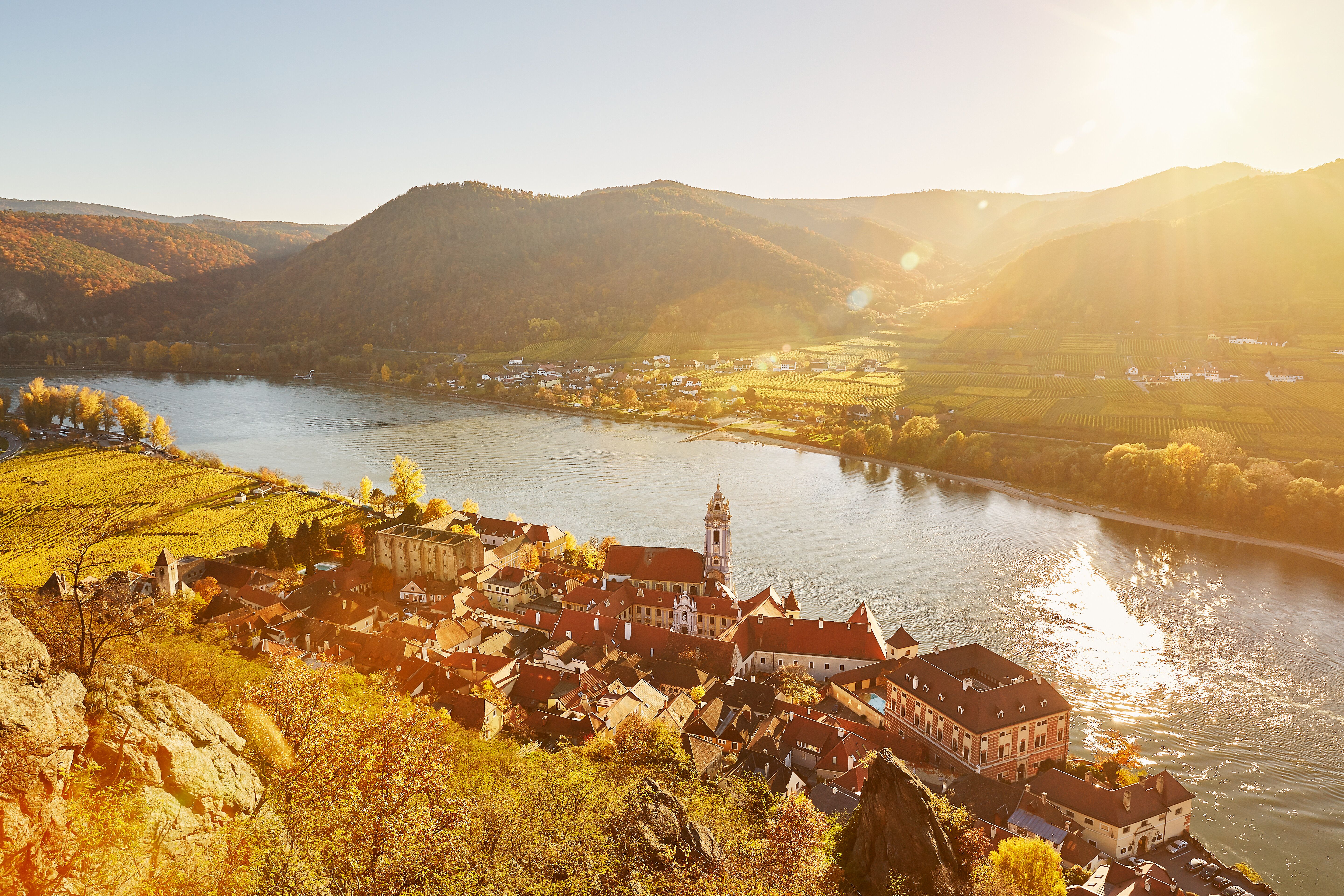 Die sanften Hügel und die glitzernde Donau umarmen das malerische Dorf, während die warmen Sonnenstrahlen die Weinberge in goldenes Licht tauchen. Hier, wo die Natur und die Geschichte harmonisch verschmelzen, lädt die Umgebung zu unvergesslichen Erlebnissen ein.