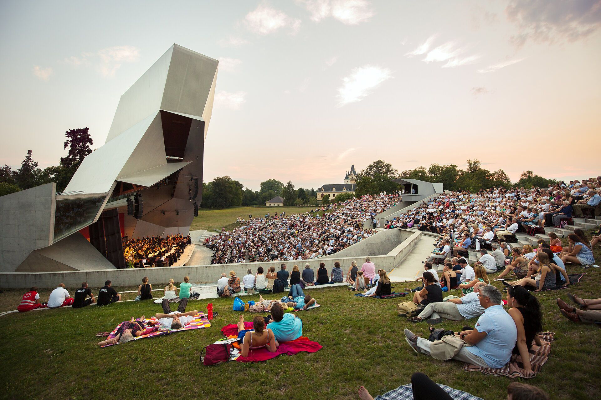 Ein unvergessliches Konzert unter freiem Himmel, umgeben von der beeindruckenden Architektur des Wolkenturms. Die sanften Klänge der Musik verschmelzen mit der malerischen Kulisse, während die Zuschauer auf der Wiese entspannen und die Atmosphäre genießen.