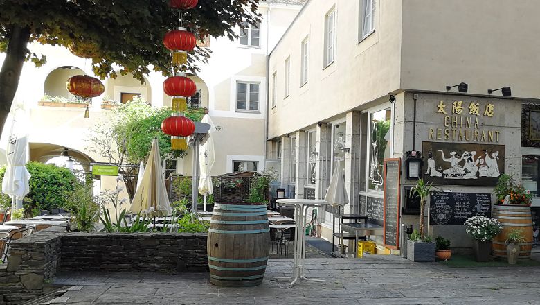 Ein chinesisches Restaurant mit roten Laternen und Außenbereich.