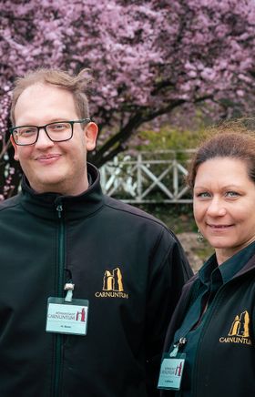 Zwei Kulturvermittler der Römerstadt Carnuntum stehen in einem römischen Garten. 
