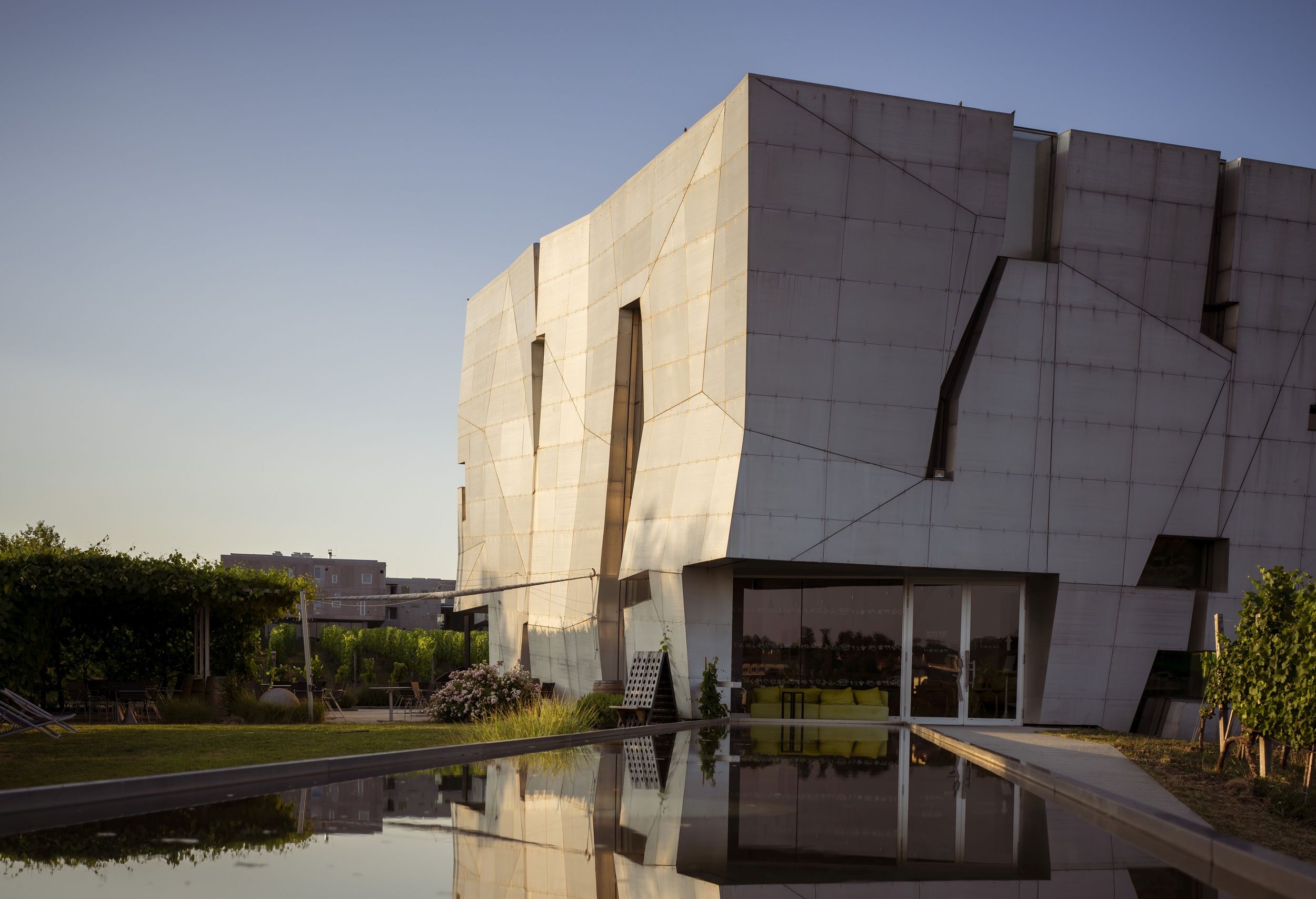 Modern architecture of a building with reflective water in the foreground.