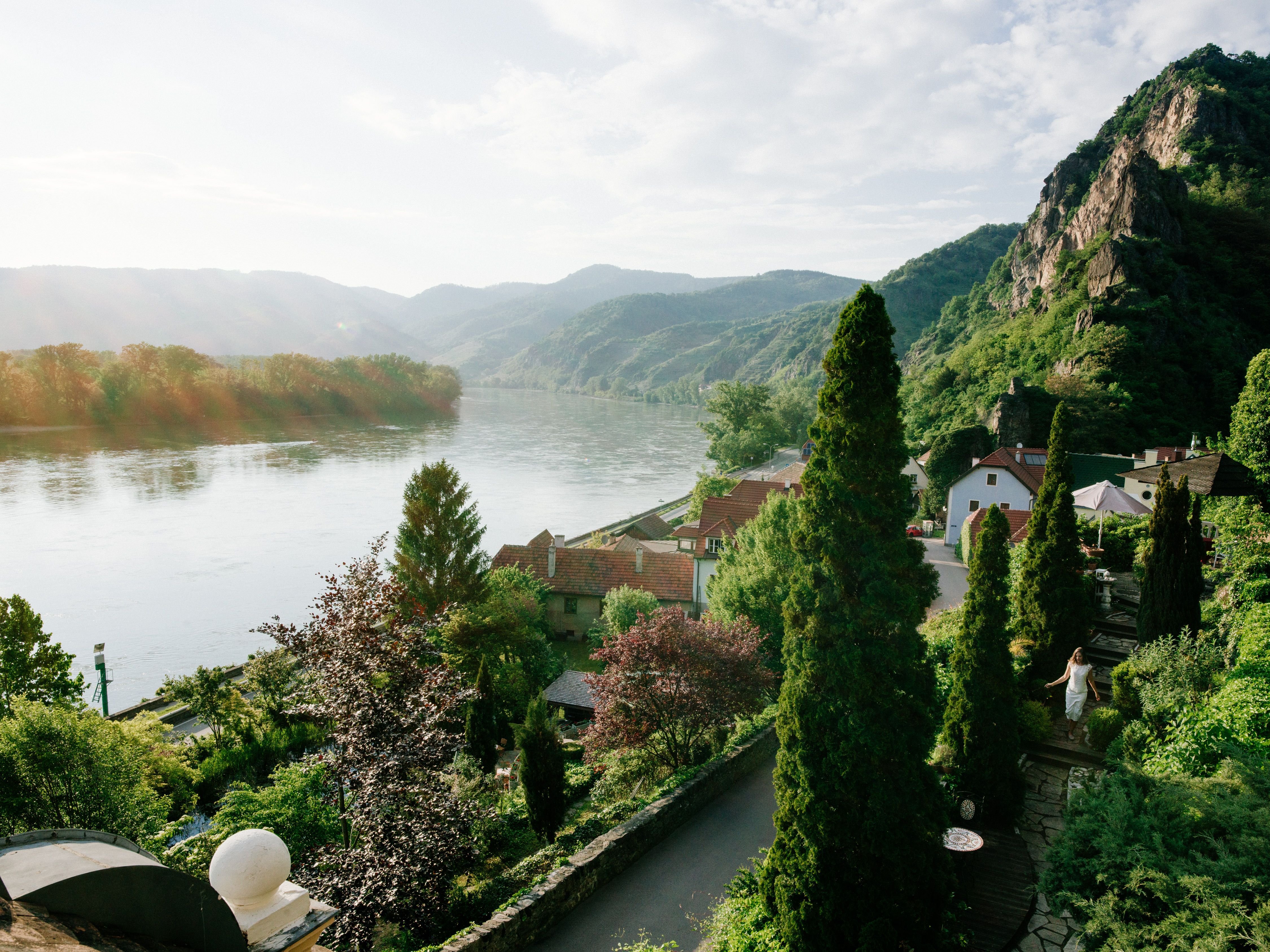 Blick auf Flusslandschaft mit Bergen und Häusern.