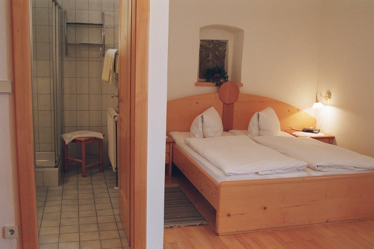 A cozy bedroom with double bed and adjoining bathroom.
