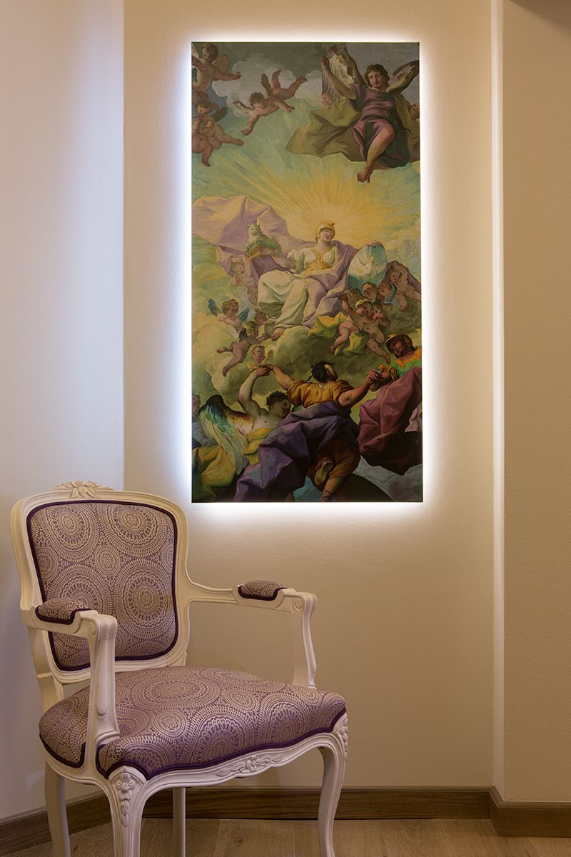 Ein Lehnsessel steht vor einem bunten Gemälde.