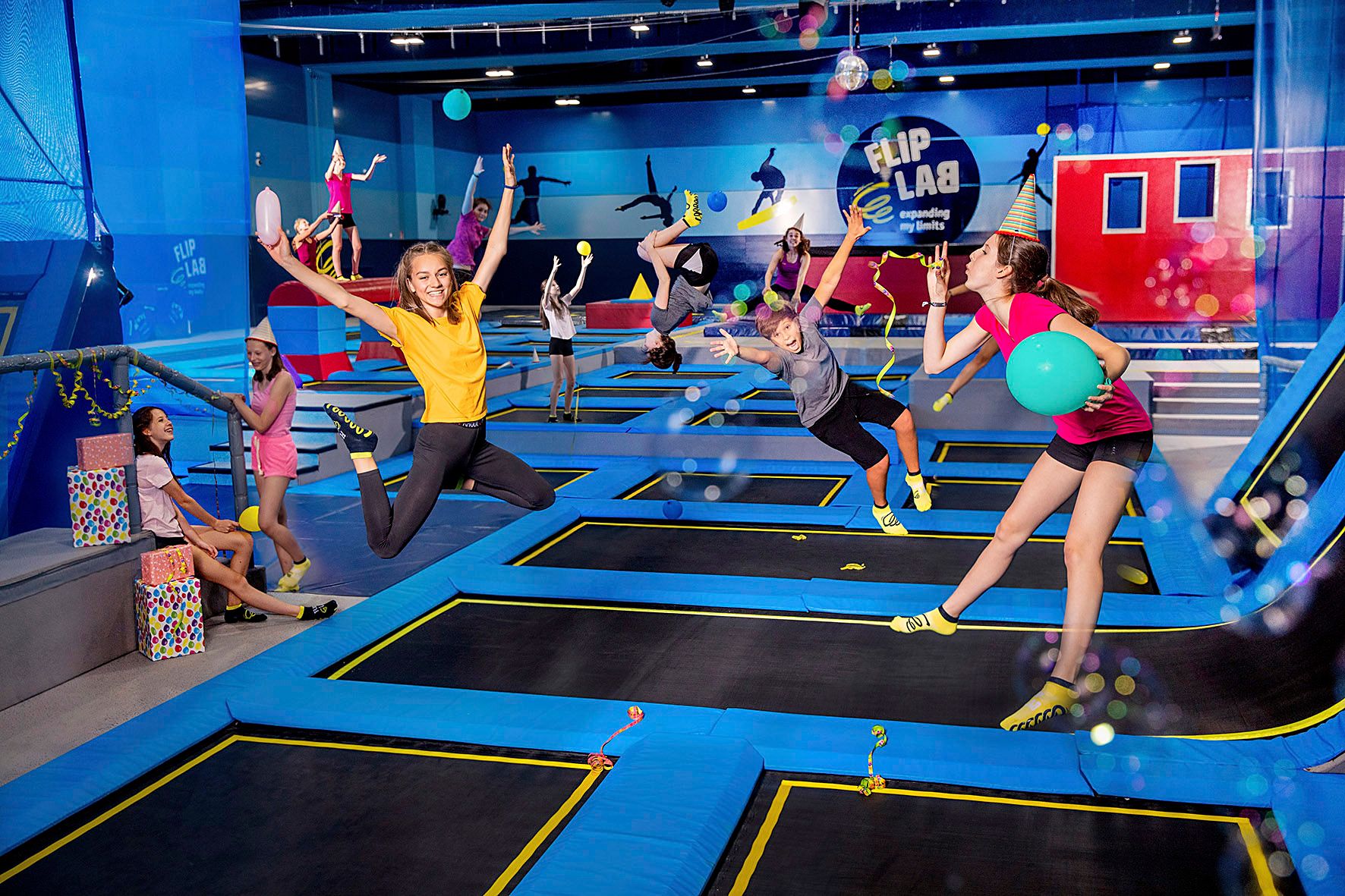 Menschen springen auf Trampolinen in einer Halle mit dem Logo 'Flip Lab'.