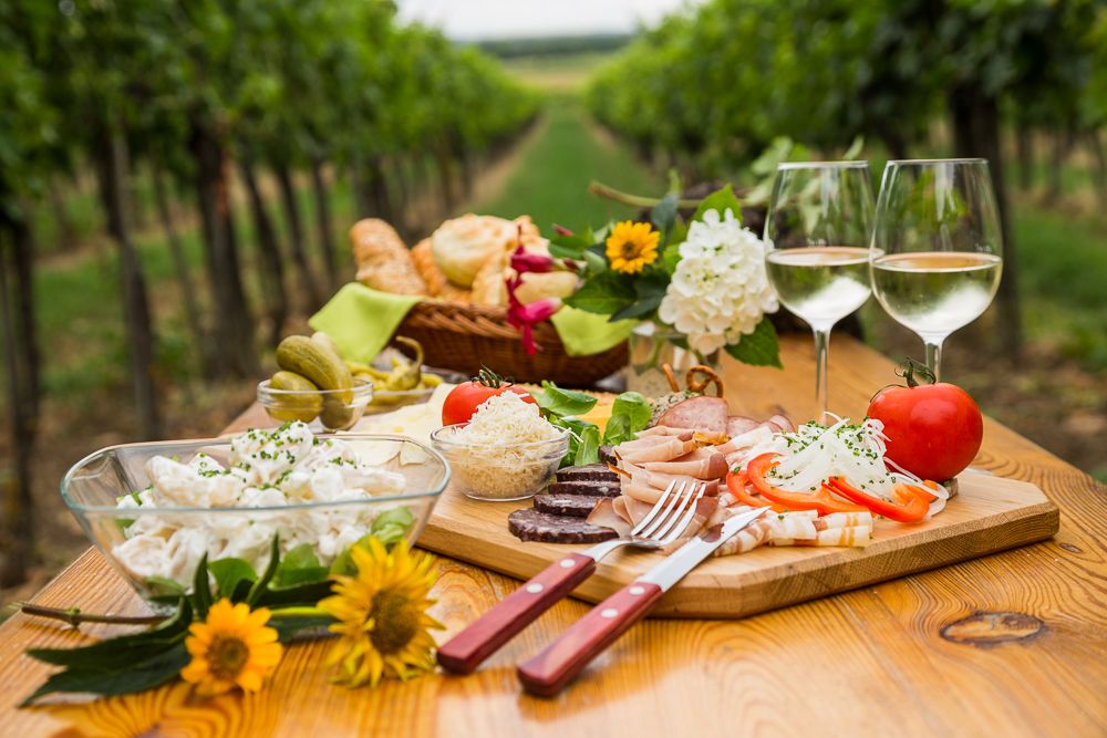 Heurigenjause auf einem Holztisch im Weinberg.