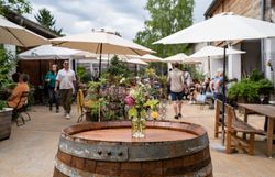 Innenhof mit einem Weinfass auf dem Blumen stehen