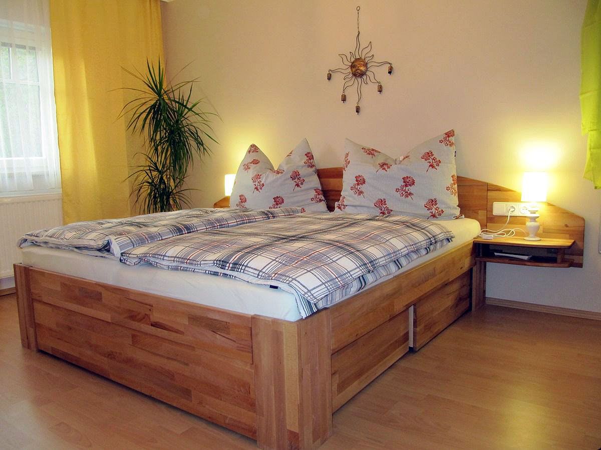 Gemütliches Schlafzimmer mit Doppelbett, Pflanzen und Wanddekoration.