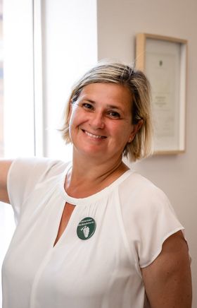 Blonde Frau von den Traisentaler Weinbegleitern lächelt in die Kamera und zeigt auf einer Karte die Regionen.