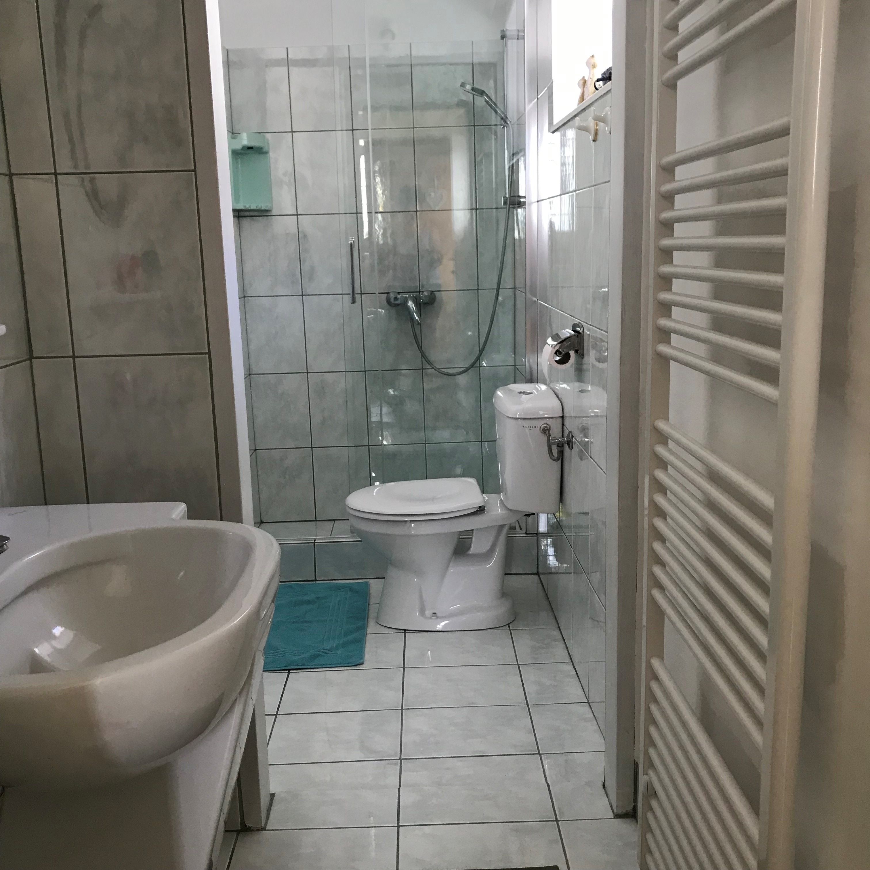 Modernes Badezimmer mit Dusche, Toilette und Waschbecken.