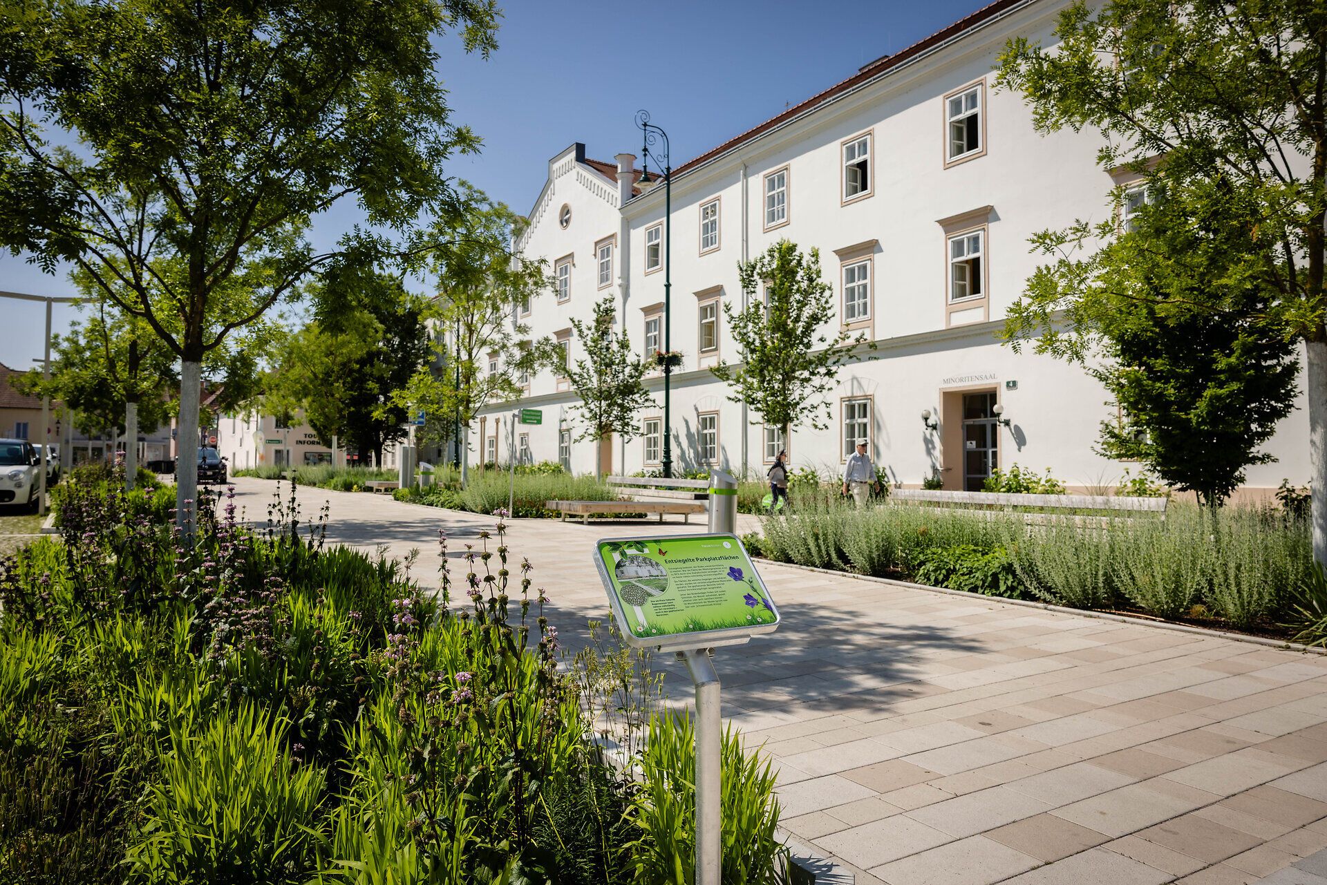 Begrünter Minoritenplatz in Tulln, Blick auf das Rathaus mit Informationstafel über Pflanzenvielfalt