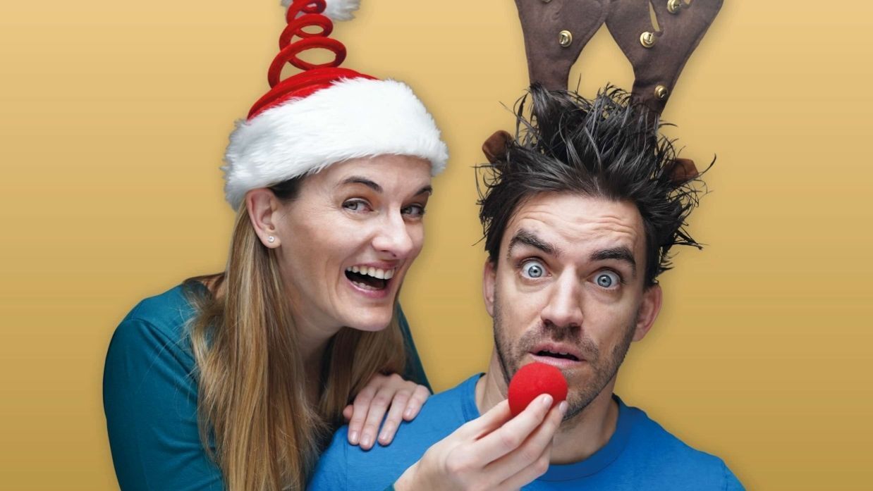 Eine Frau mit Weihnachtsmütze und ein Mann mit Geweih am Kopf
