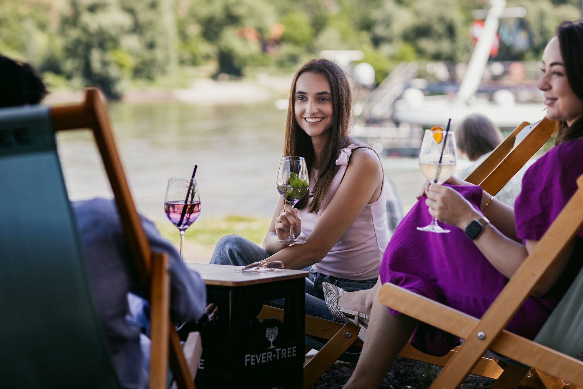 Drei junge Menschen sitzen beisammen und prosten sich zu.