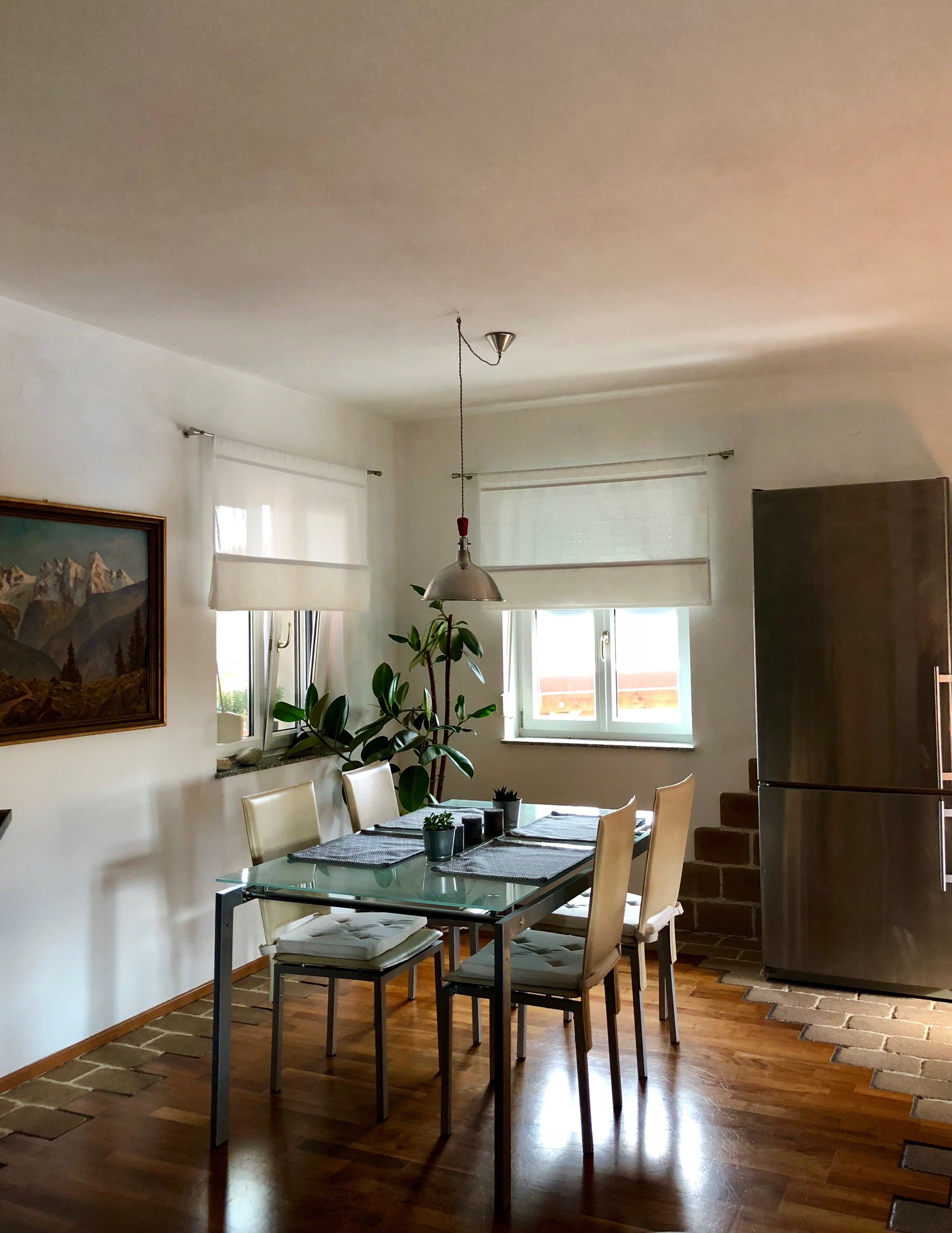 Offener Wohn- und Essbereich mit Tisch, Stühlen und natürlichem Lichteinfall.