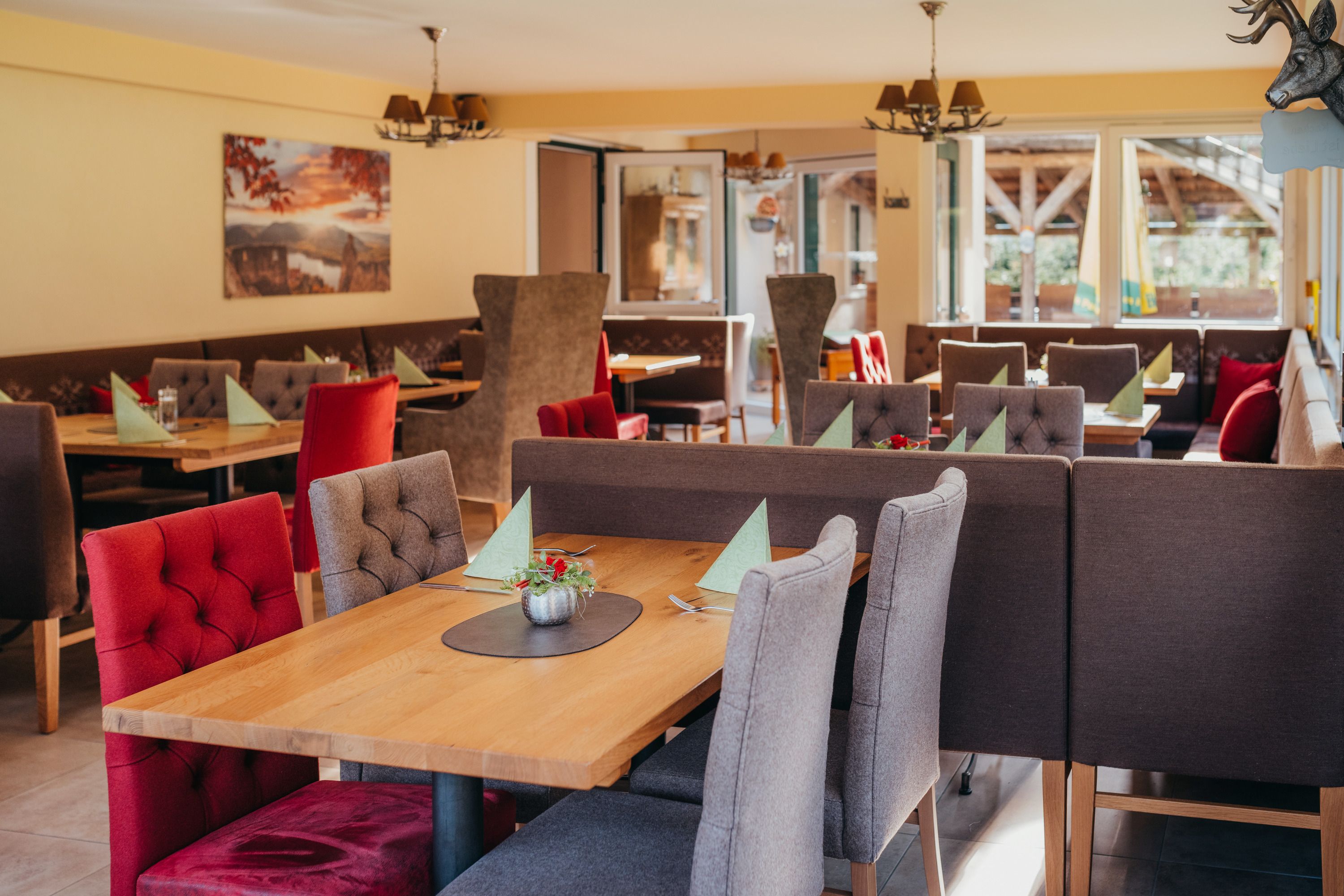 Gemütliches Restaurant mit Holztischen und gepolsterten Stühlen.