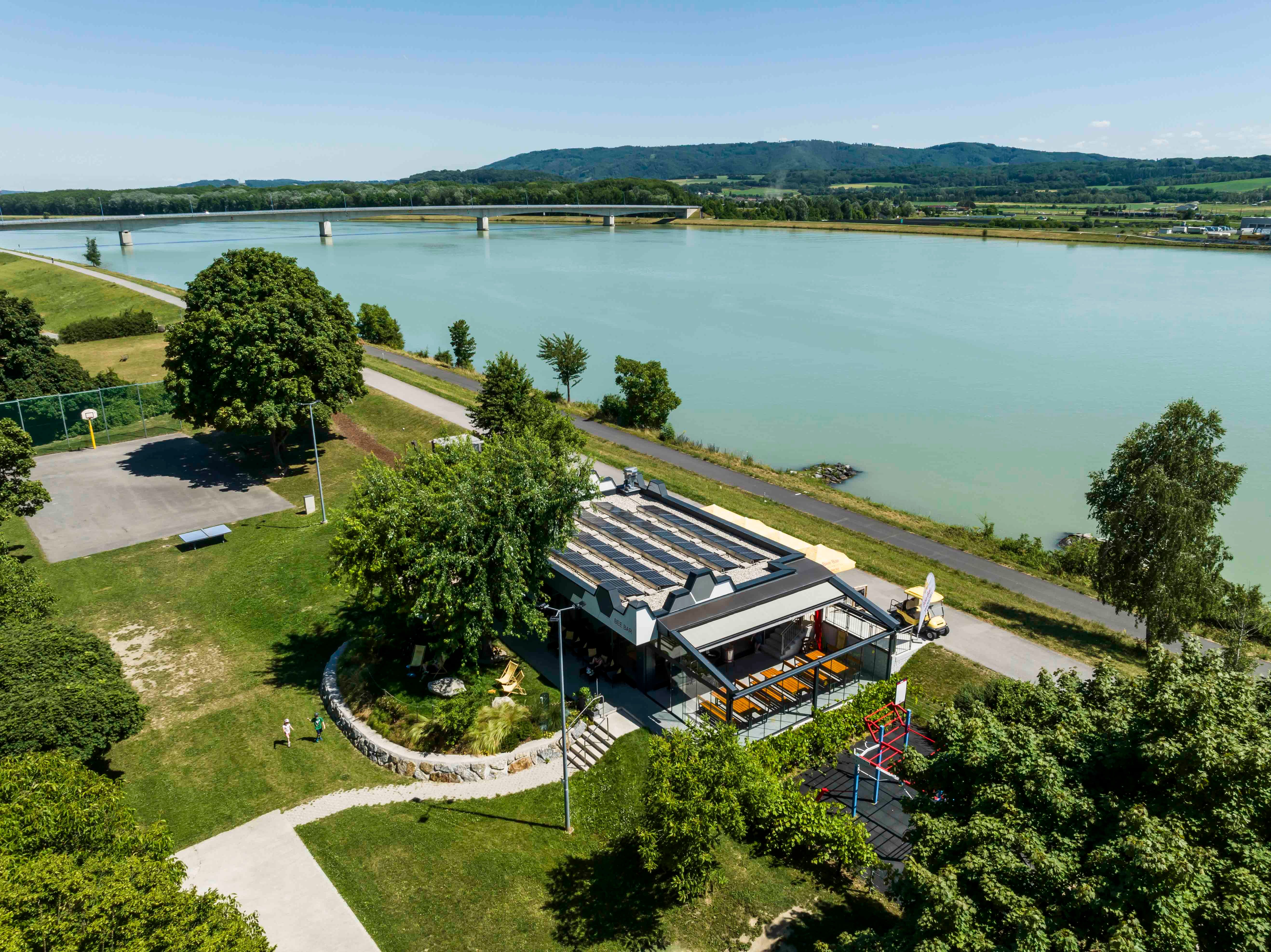 Luftaufnahme der Bee Bar in Klein-Pöchlarn am Flussufer mit umliegender Landschaft.