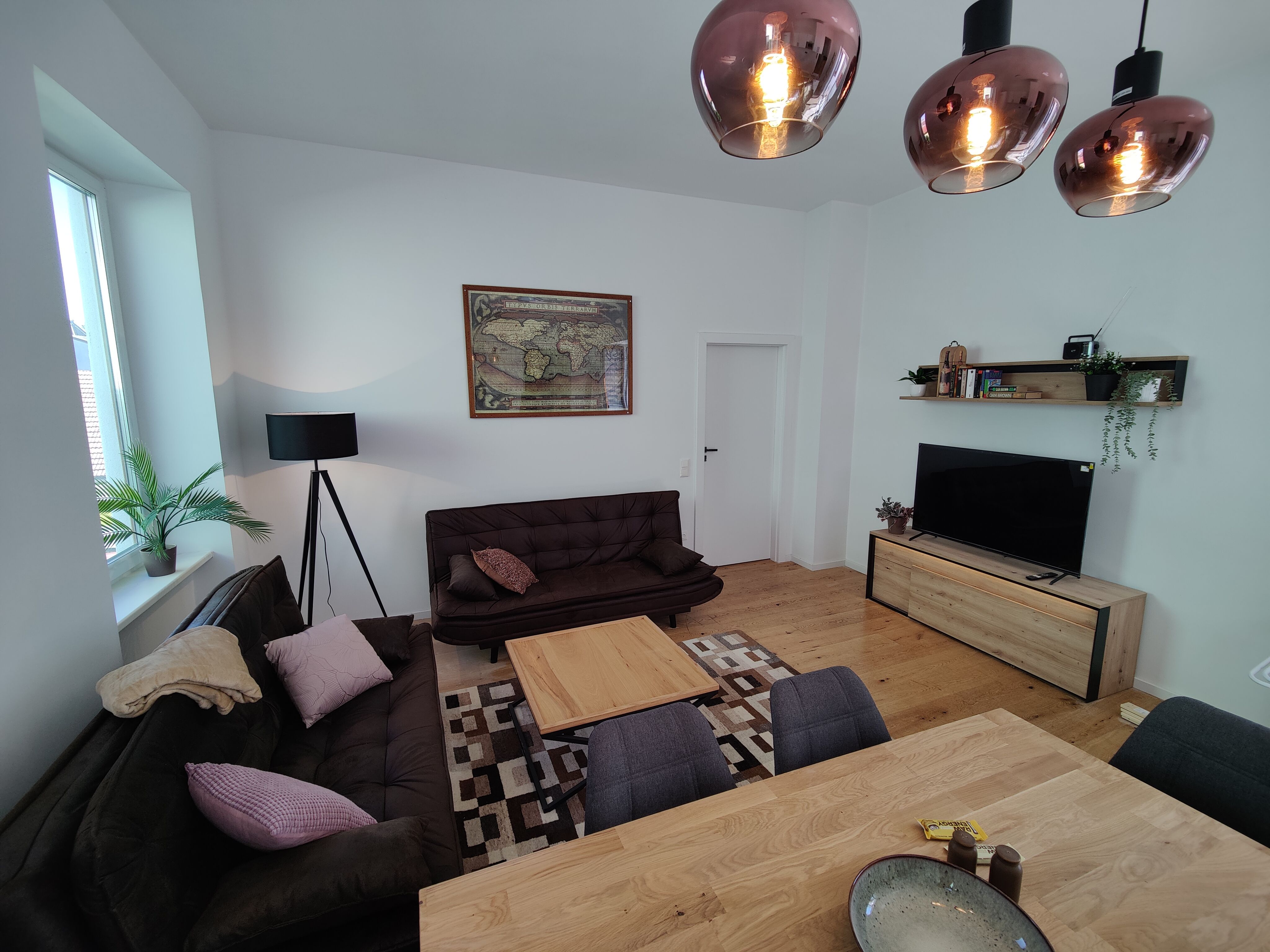 gemütliches Wohnzimmer mit Holzboden Couch und Fernseher