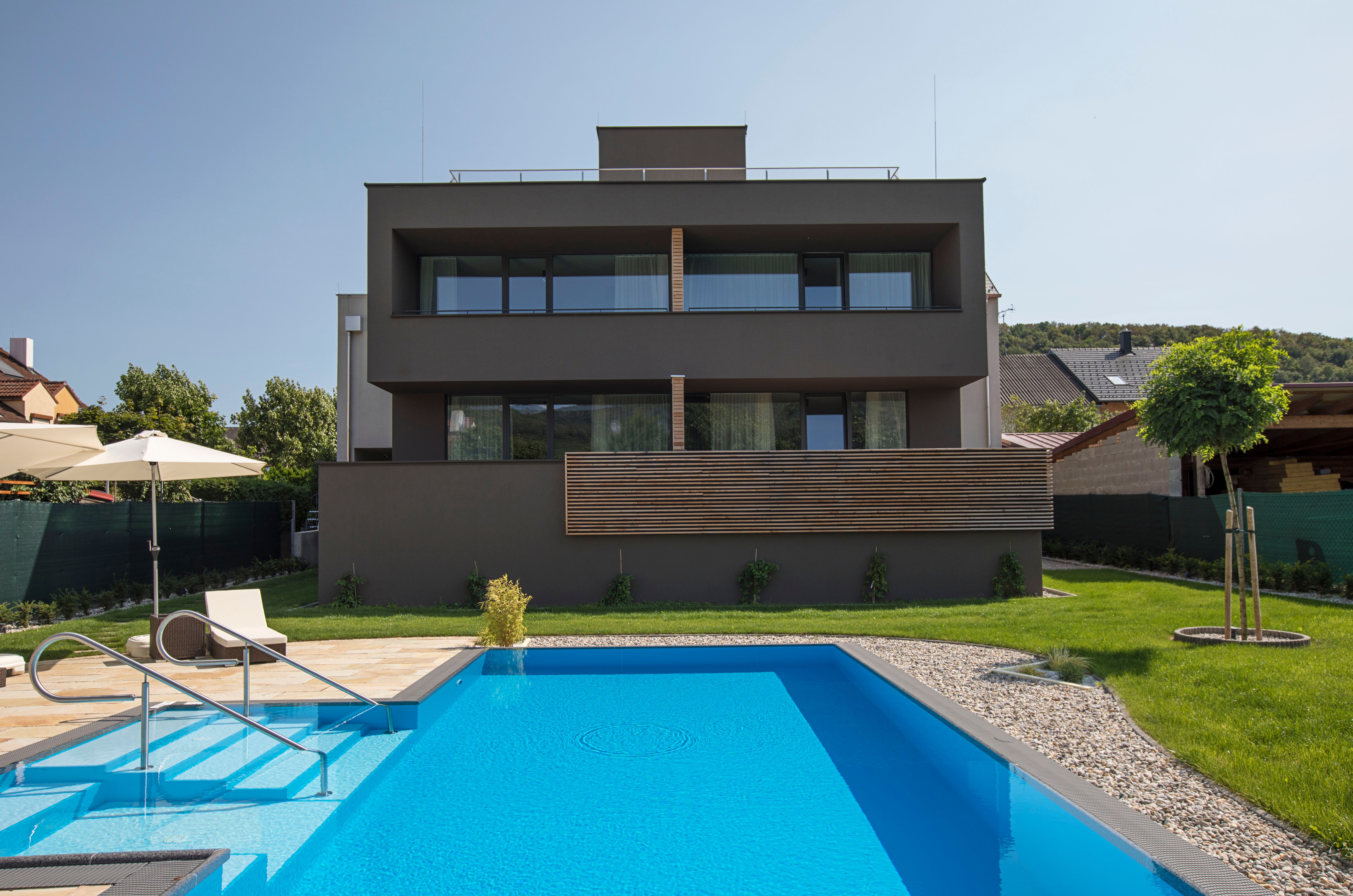 Rückansicht eines modernen Gebäudes mit Pool und Garten.