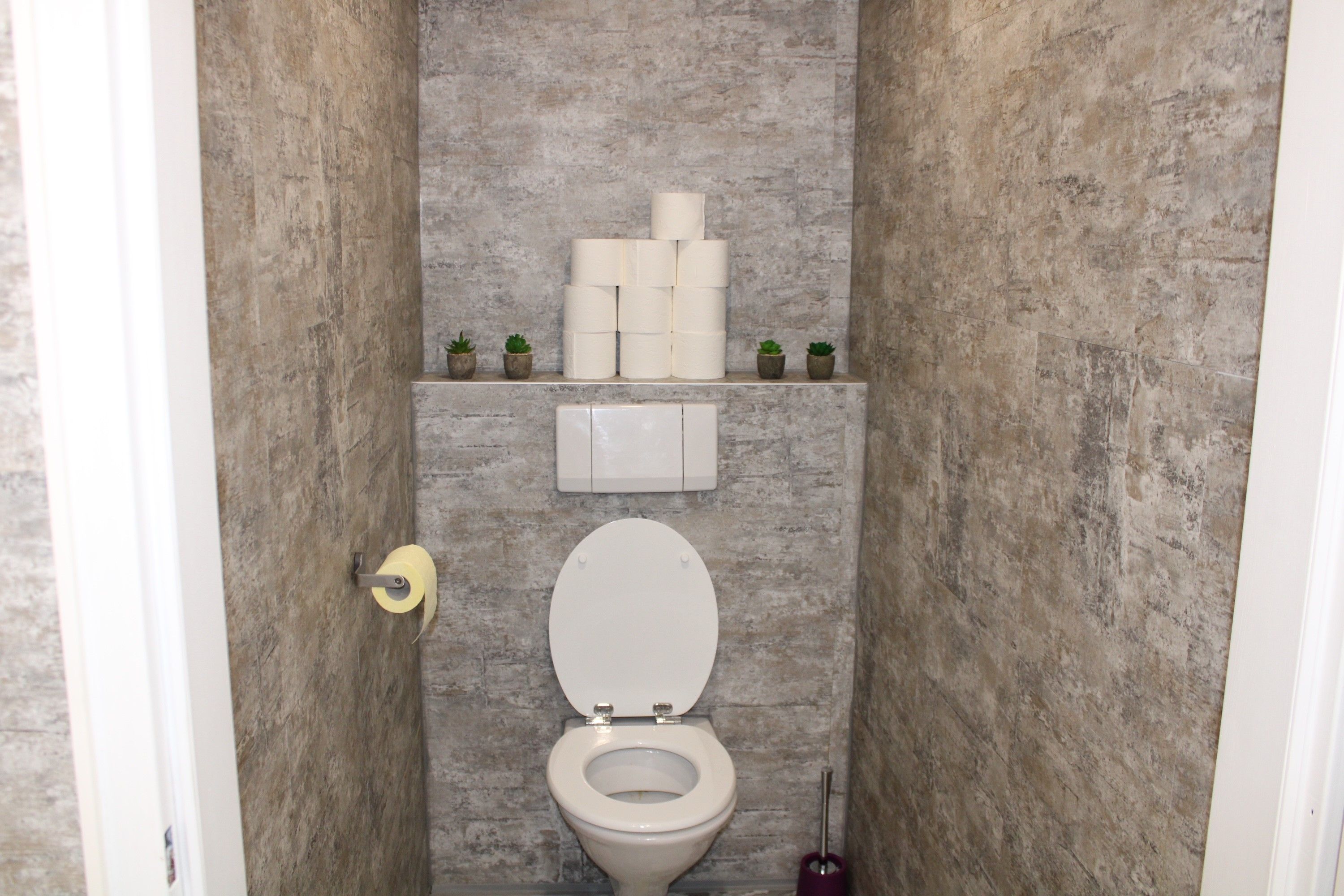 Modernes WC mit grauen Fließen