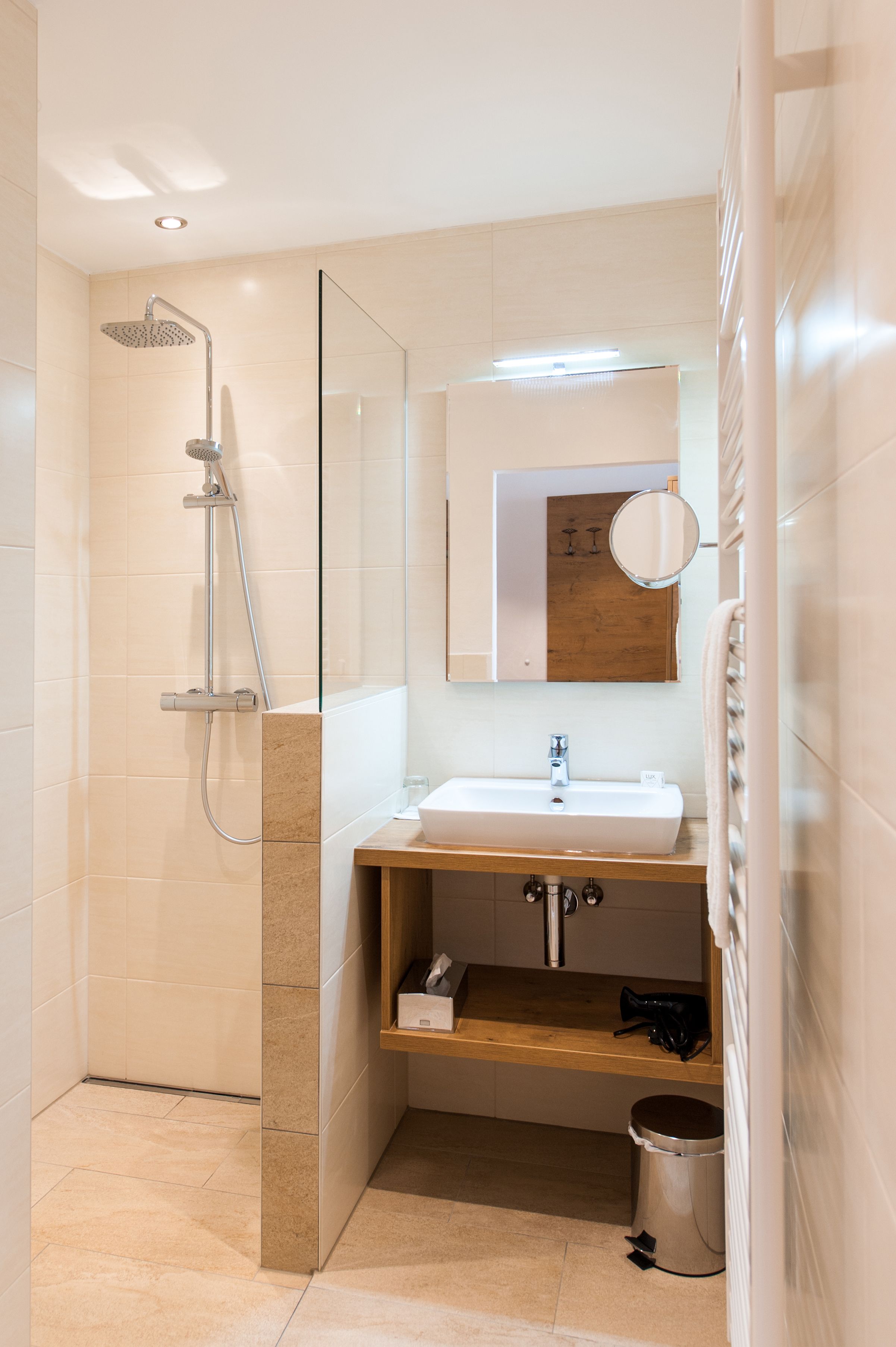 Modernes Badezimmer mit Dusche, Waschbecken und Spiegel.