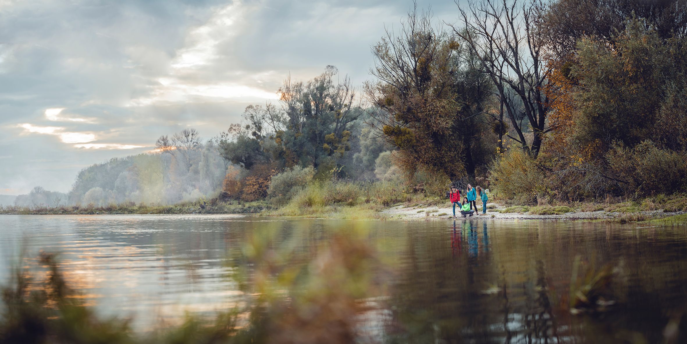 Donau und am Donauufer steht eine Wandergruppe 