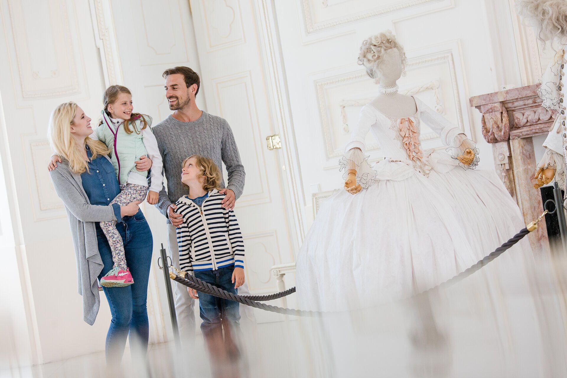 Eine Familie genießt einen entspannten Tag in einem prachtvollen Schloss, umgeben von kunstvollen Ausstellungsstücken. Die Kinder sind fasziniert von der historischen Atmosphäre, während die Eltern die Schönheit der Umgebung bewundern. Hier wird der Sommer zu einem unvergesslichen Erlebnis voller Freude und Entdeckung.