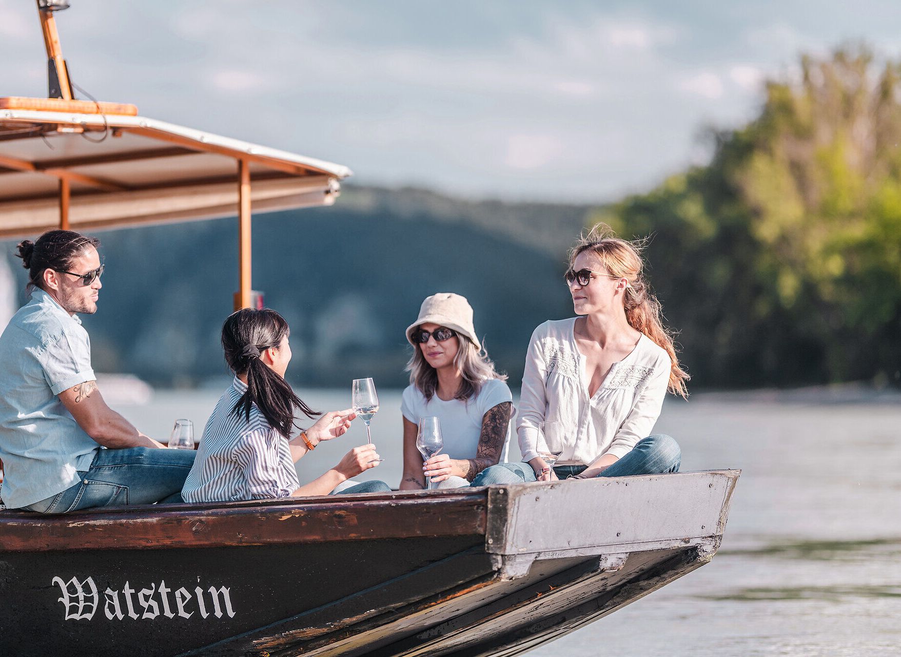 Eine Holzzille mit Menschen fährt auf der Donau in der Wachau.