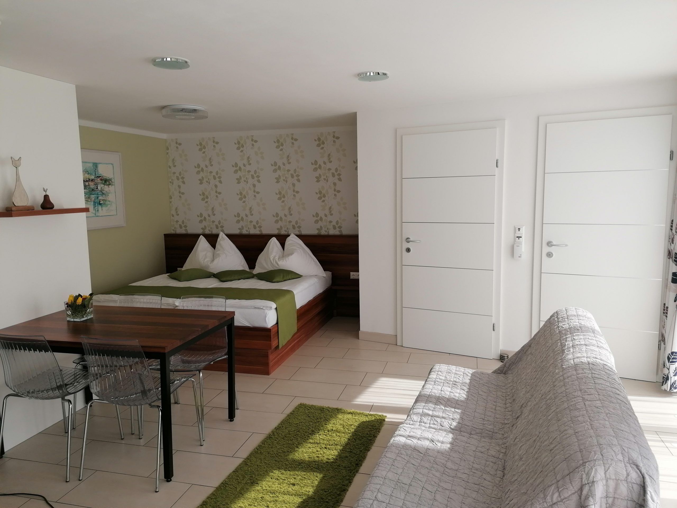 Raum mit Doppelbett und zwei weißen Eingangstüren