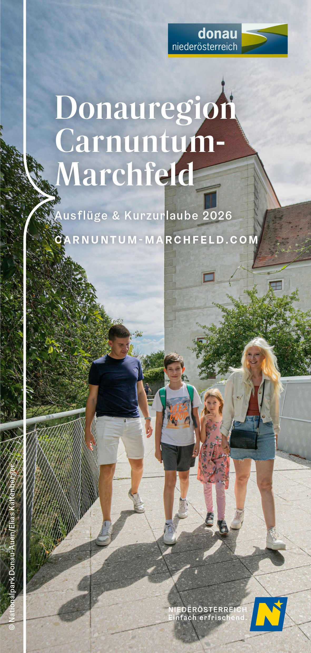 Eine junge Familie bewegt sich weg von Schloss Orth in Richtung Schlossinsel.