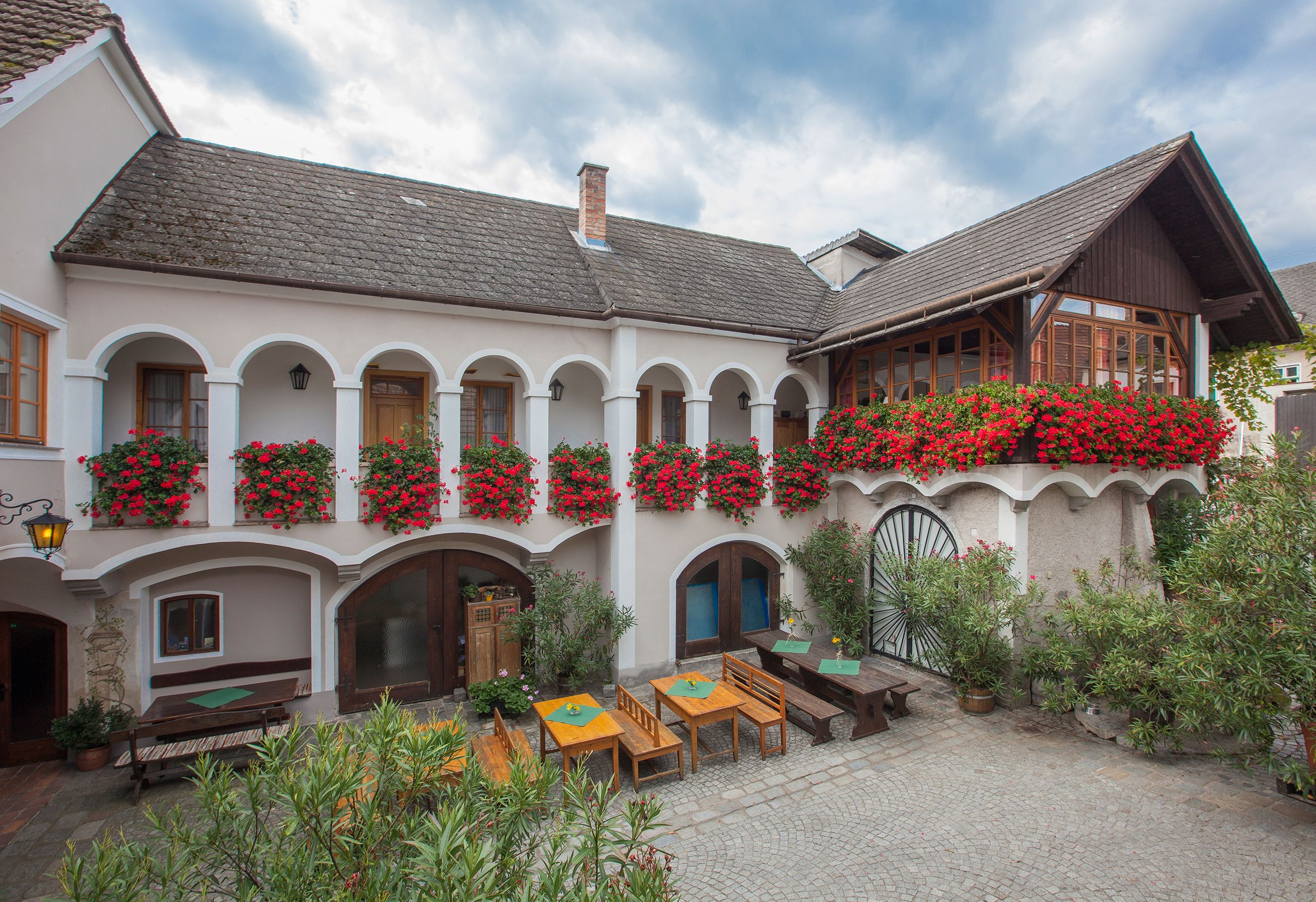 Traditionelles Gebäude mit Arkaden und Blumenkästen.