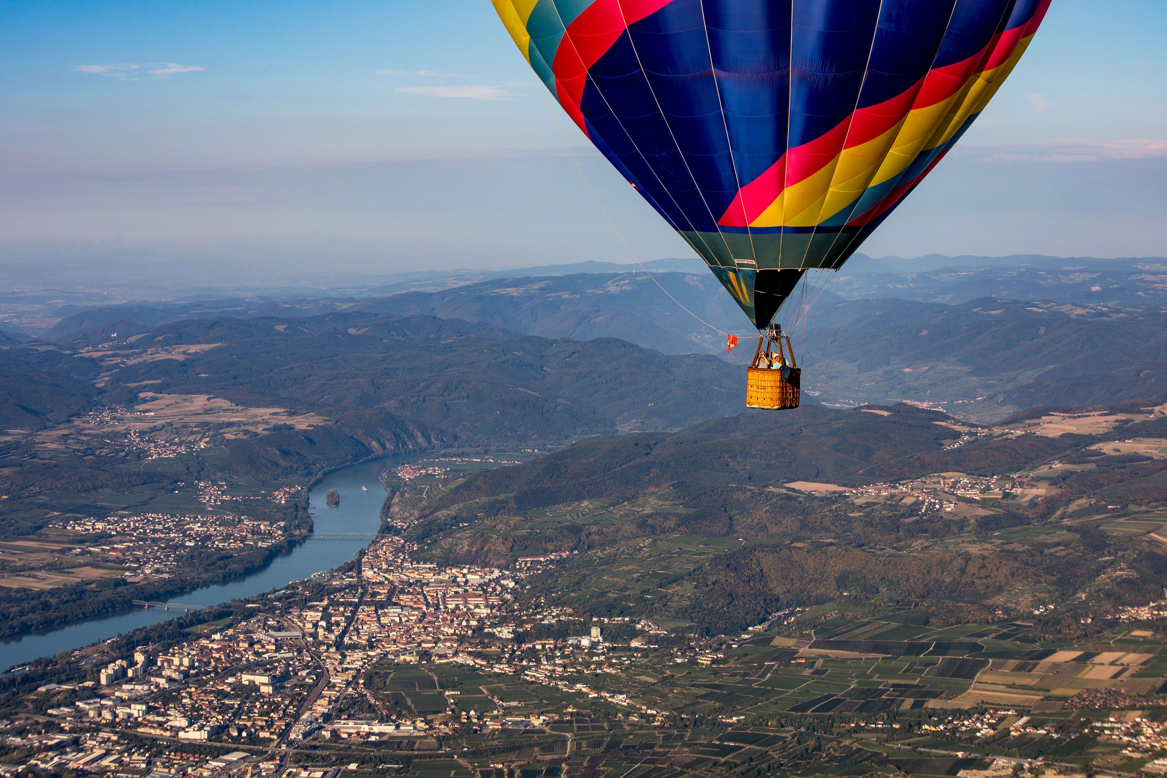 Heißluftballon über der Wachau mit Blick auf die Donau und umliegende Landschaft.