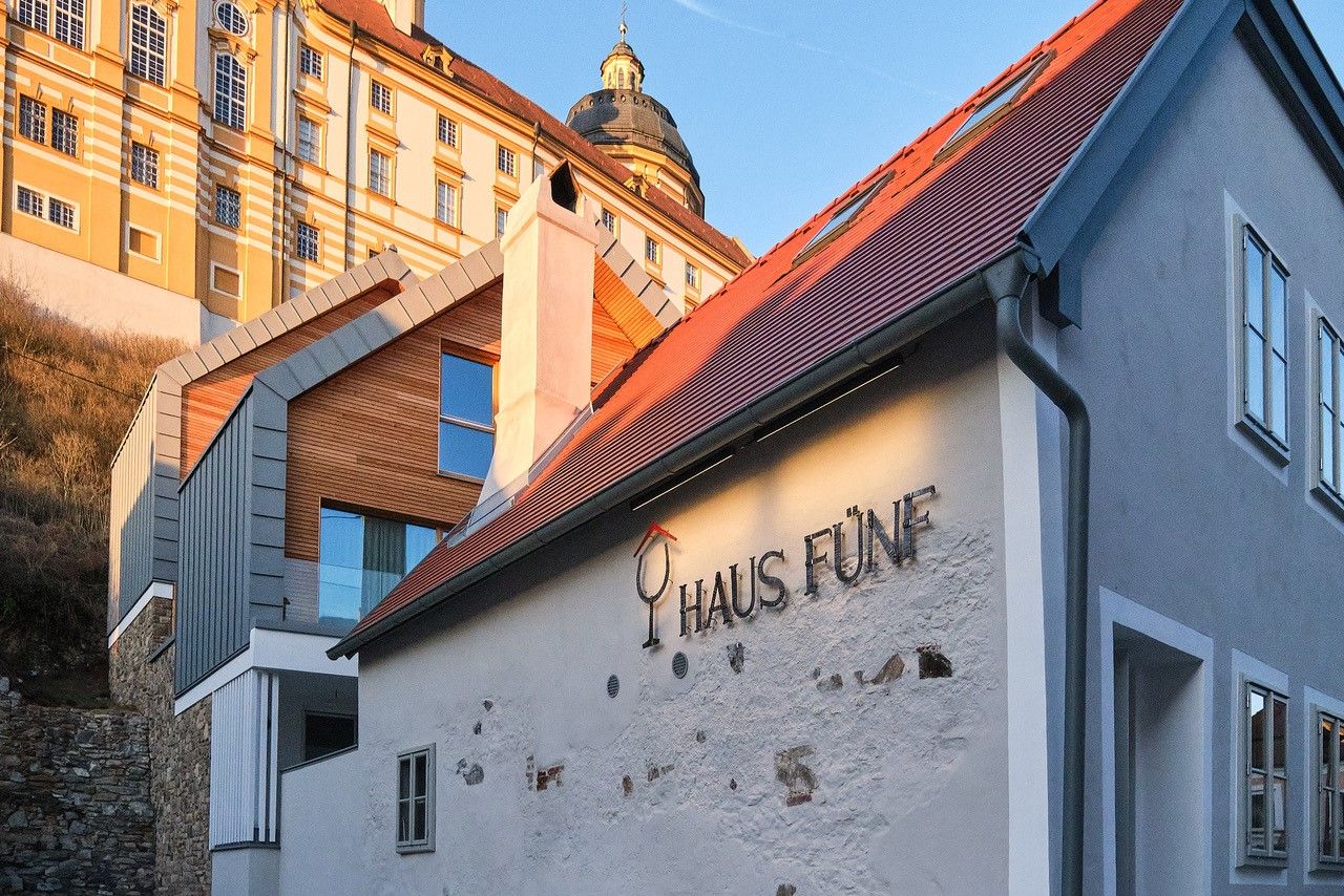 Außenansicht von Haus Fünf mit Stift Melk im Hintergrund.