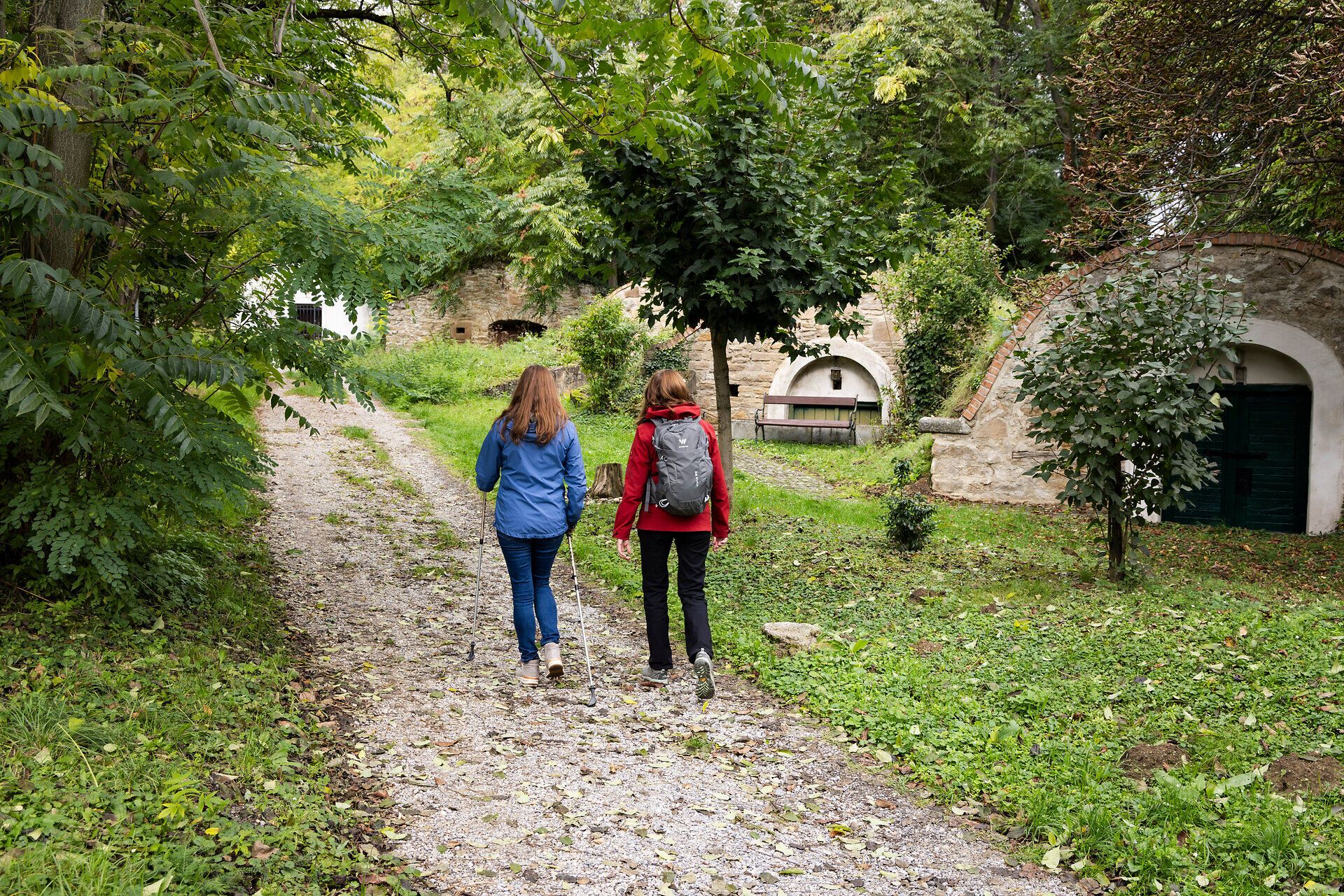 Two women on a hiking trail through a neighborhood of cellars. 