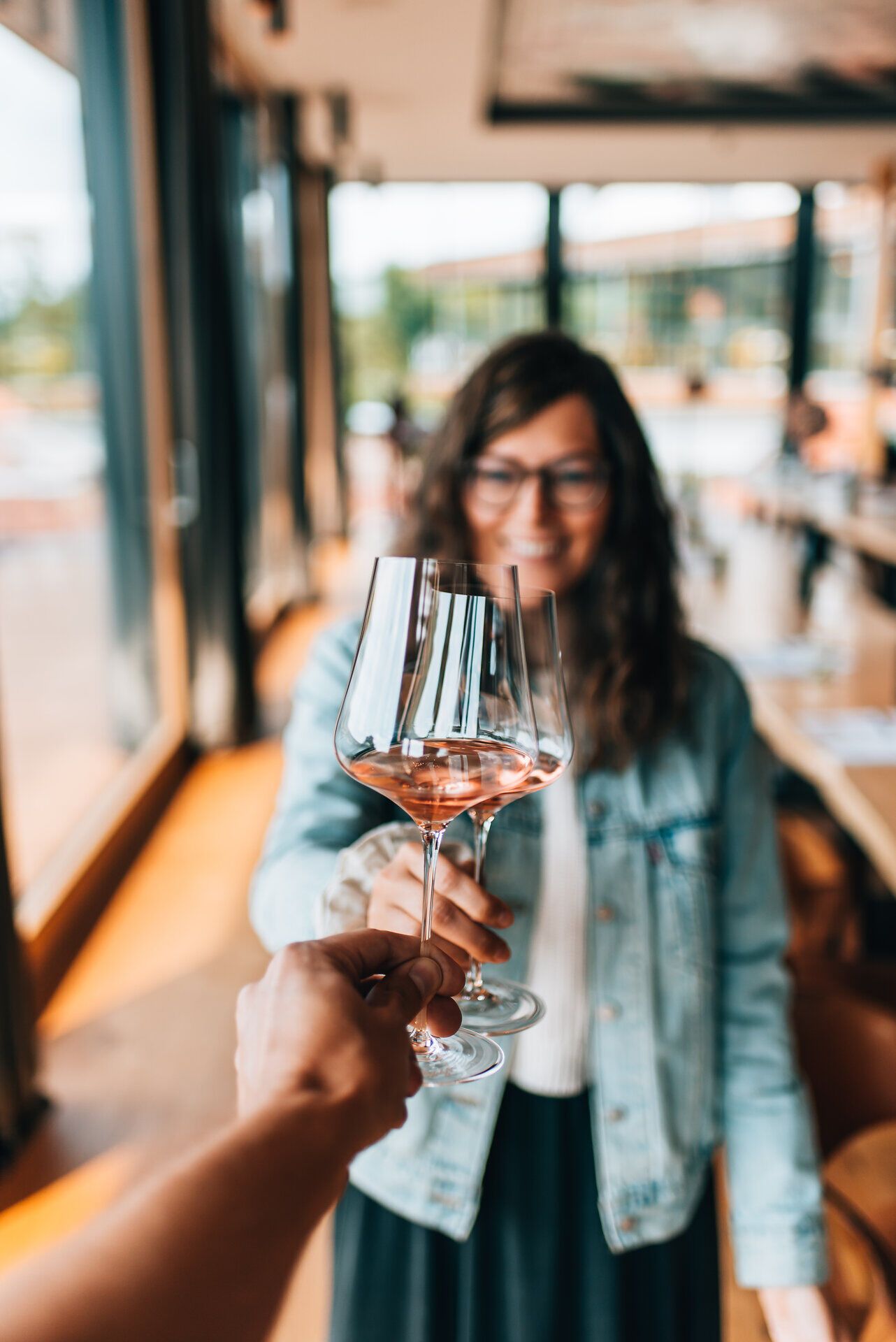 Inmitten der malerischen Weinlandschaft wird ein Glas erlesener Wein angestoßen, während die warmen Sonnenstrahlen die Gesichter der Gäste erhellen. Die entspannte Atmosphäre und die umgebenden Weinreben laden dazu ein, die köstlichen Aromen der Region zu genießen und unvergessliche Momente zu teilen.