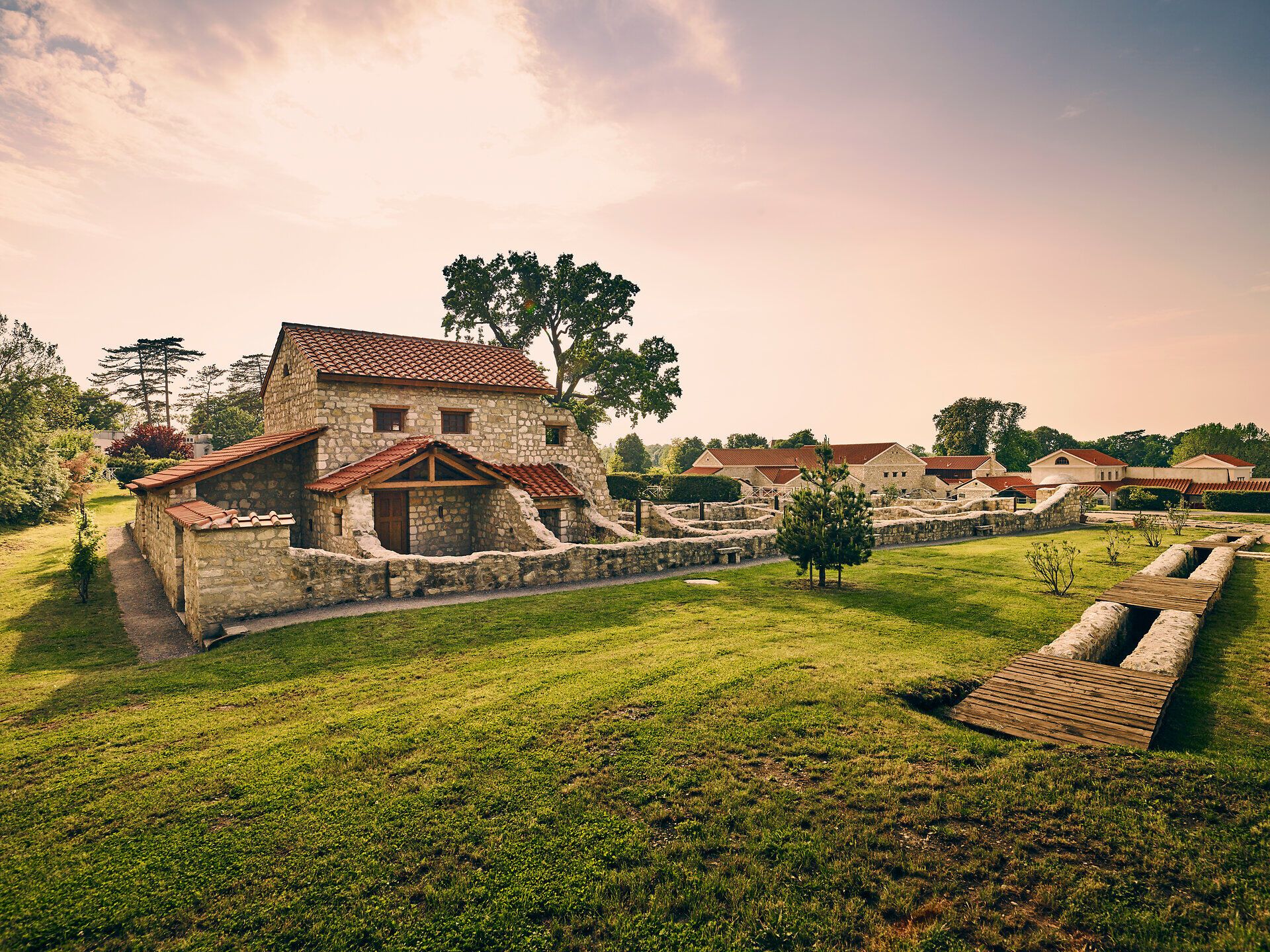 In der sanften Abenddämmerung erstrahlt die historische Architektur in warmen Farben und lädt zu einem Spaziergang durch die malerische Landschaft ein. Die harmonische Verbindung von Natur und Kultur schafft eine einladende Atmosphäre, die zum Verweilen einlädt.