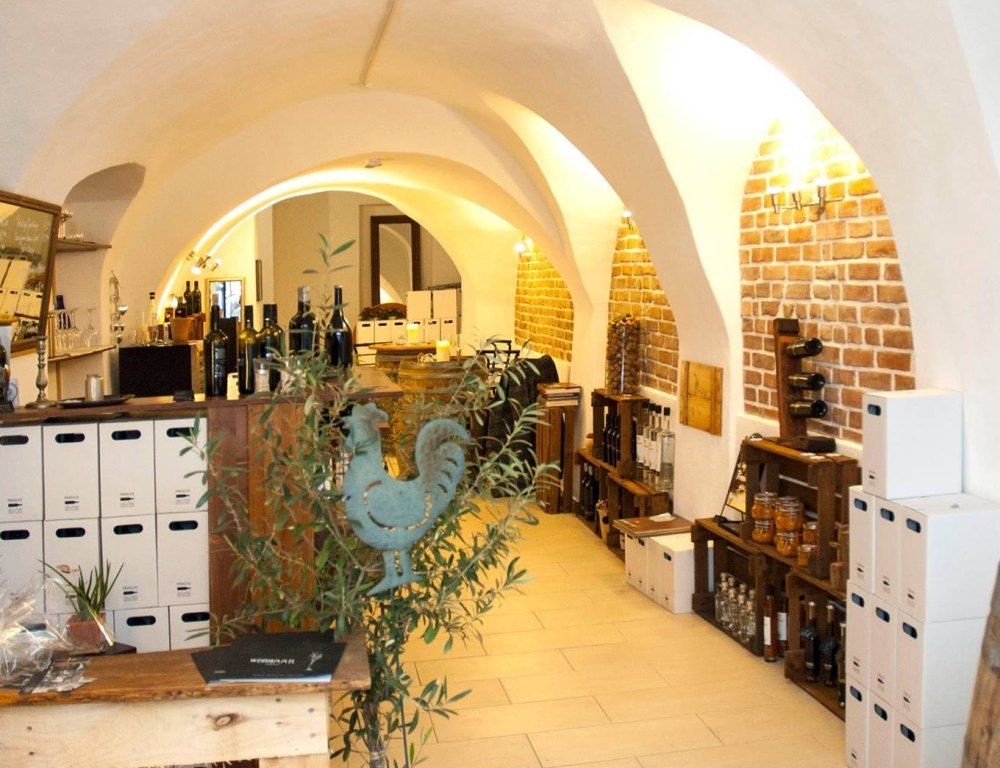 Innenansicht einer Vinothek mit Ziegelwänden und Weinflaschen.