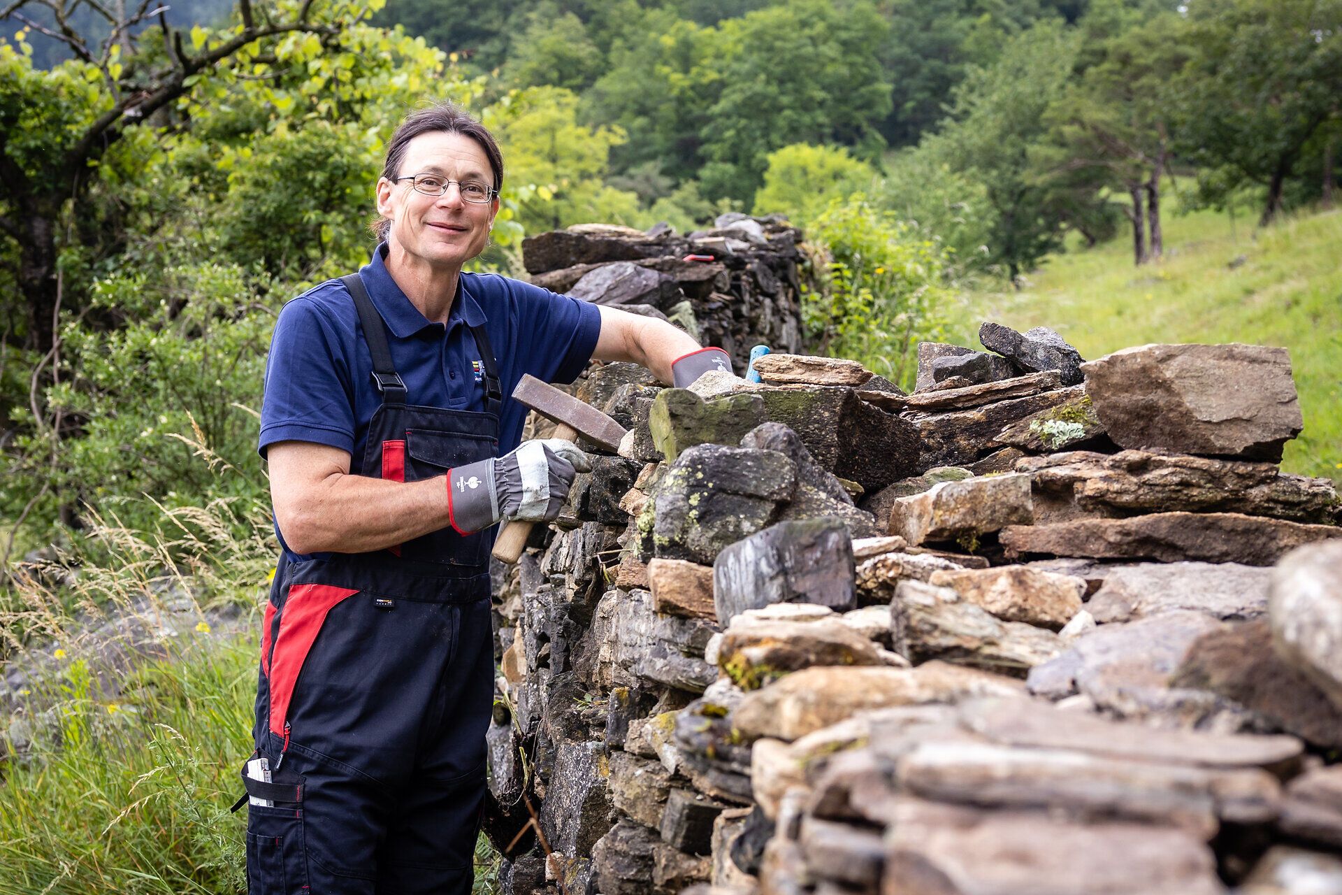 Eine Frau beim Bau einer Trockensteinmauer