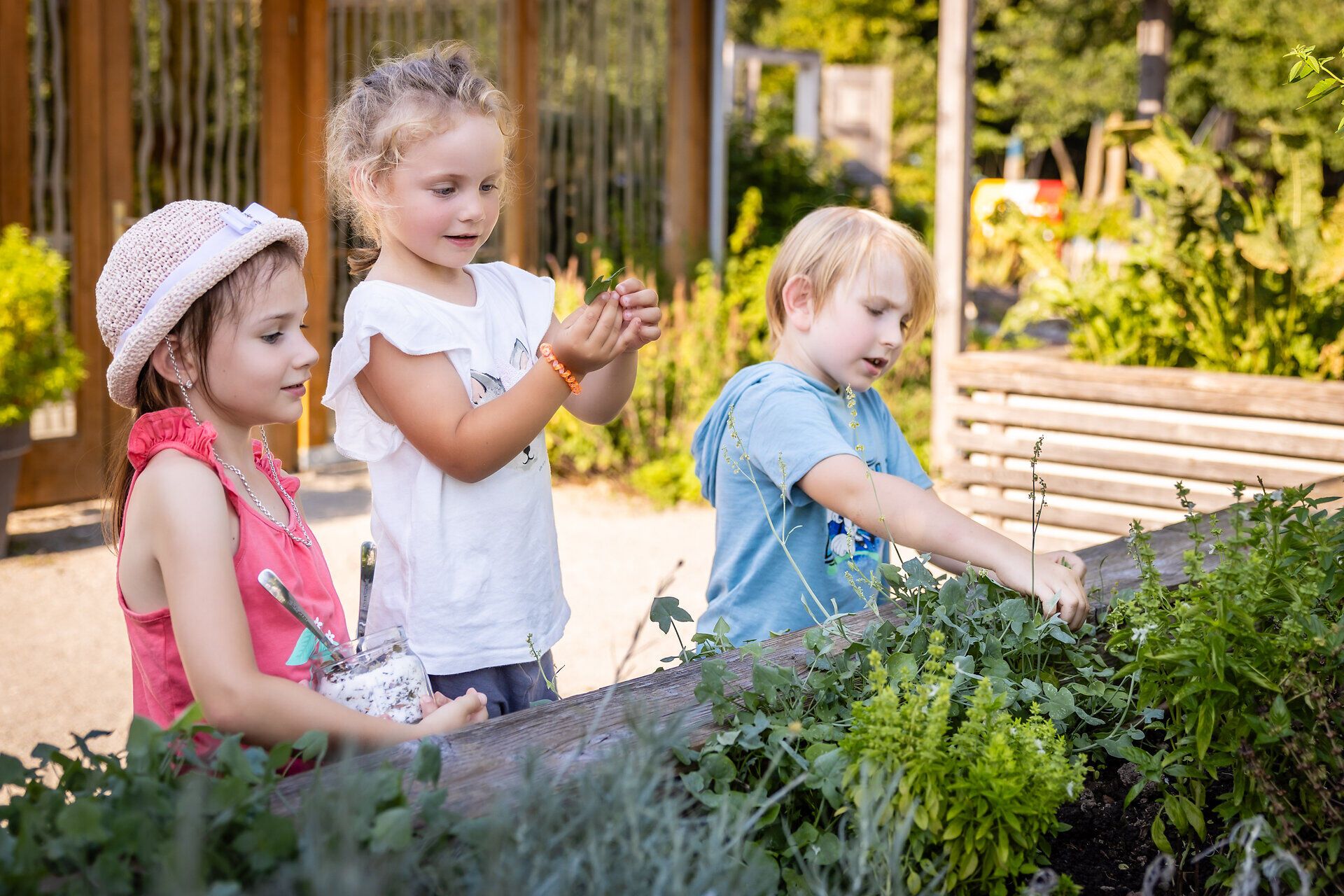 Familienfreundliches Top Ausflugsziel GARTEN TULLN. Drei Kinder erforschen ein Hochbeet. Alle sind fröhlich, haben gemeinsam Spaß an diesem sonnigen Tag.

