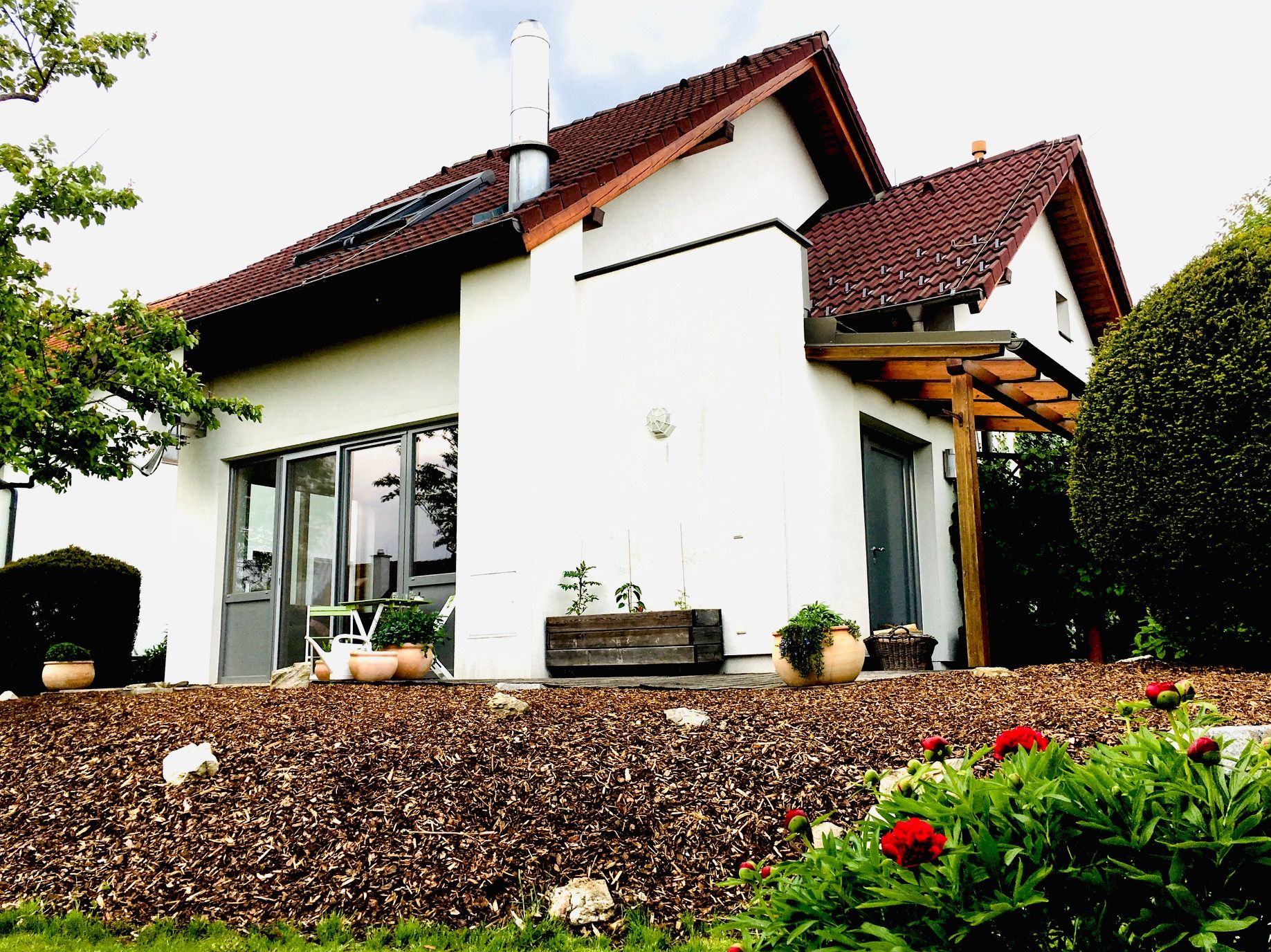 Außenansicht eines modernen Einfamilienhauses mit Garten und Terrasse.