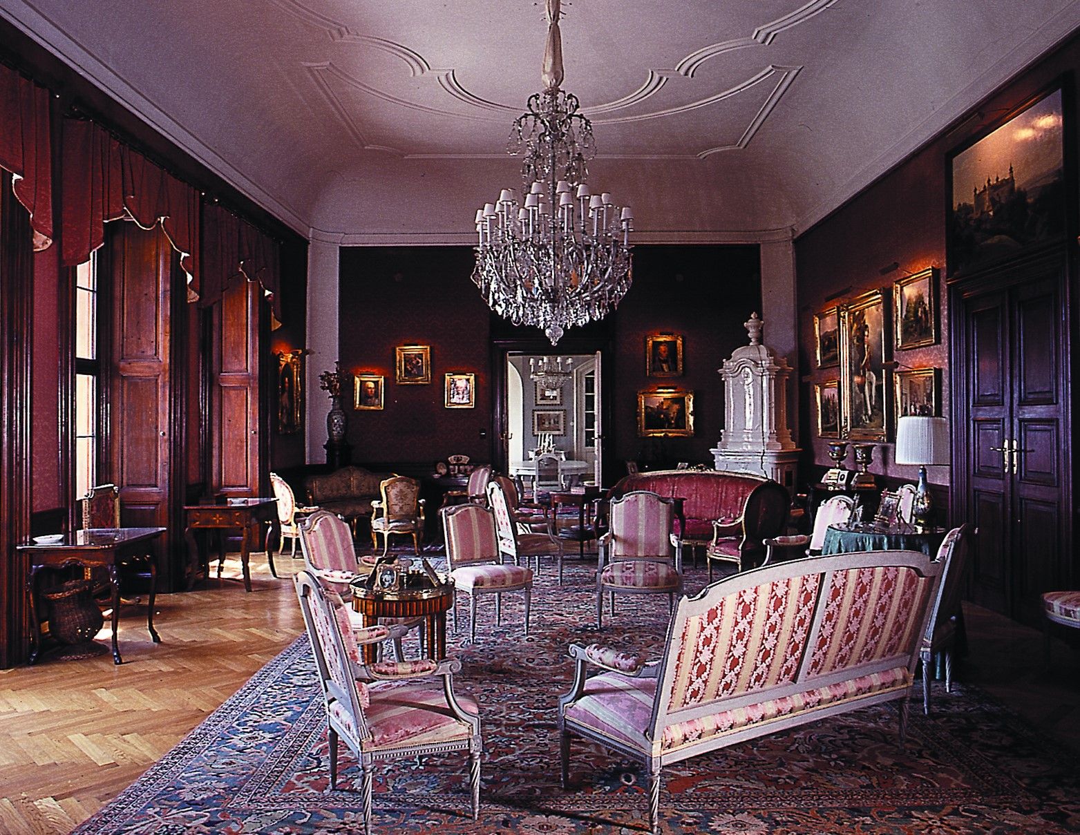 Elegant salon with antique furniture, chandelier and paintings.