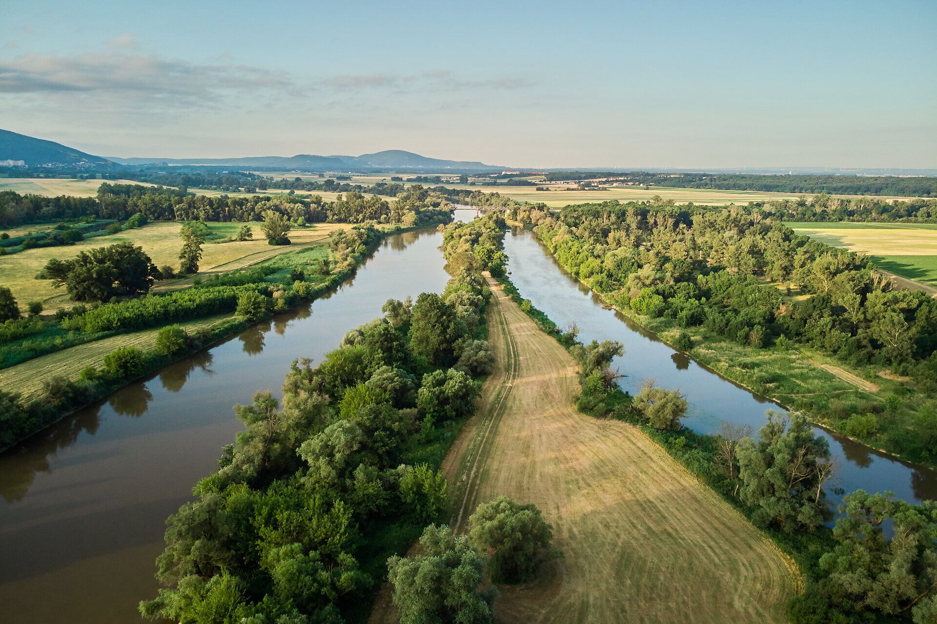 Die sanften Wiesen und der glitzernde Fluss laden zu einem entspannten Tag in der Natur ein. Umgeben von üppigem Grün und malerischen Ausblicken, bietet dieser Ort die perfekte Kulisse für unvergessliche Erlebnisse im Freien.