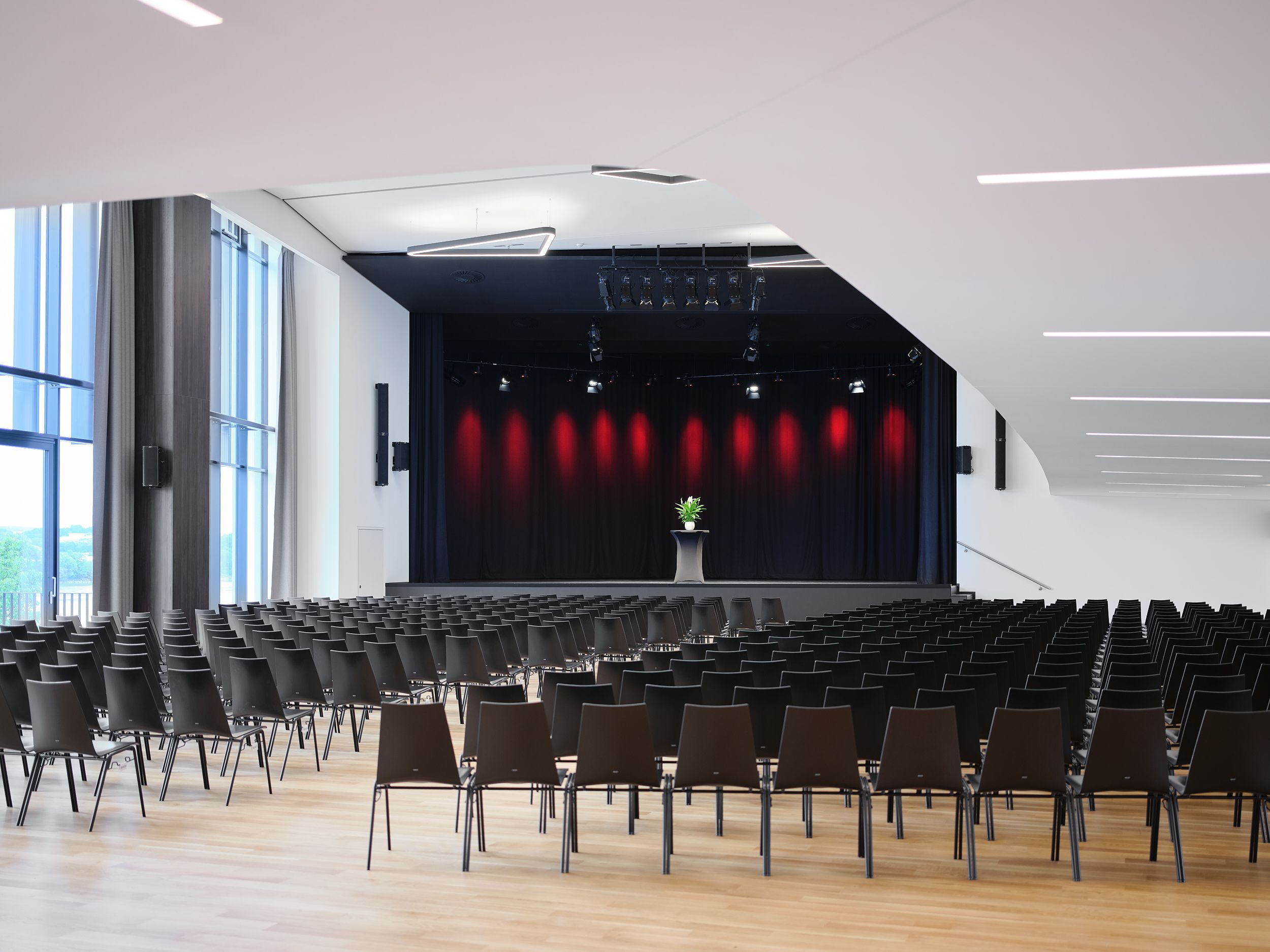 Empty event room with stage and rows of chairs in the Stadthalle Ybbs.