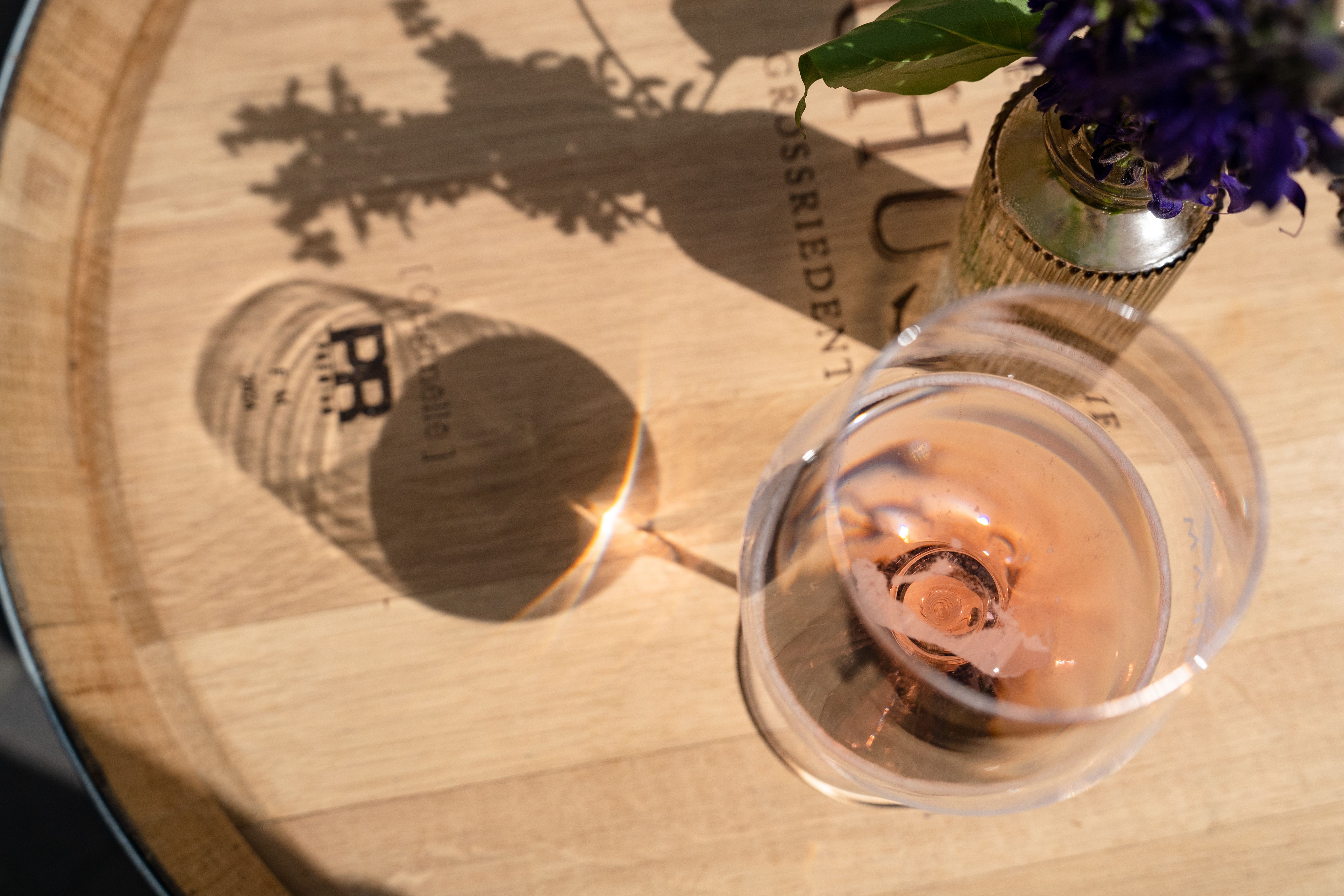 Glas mit Frizzante befüllt auf einem Weinfass.