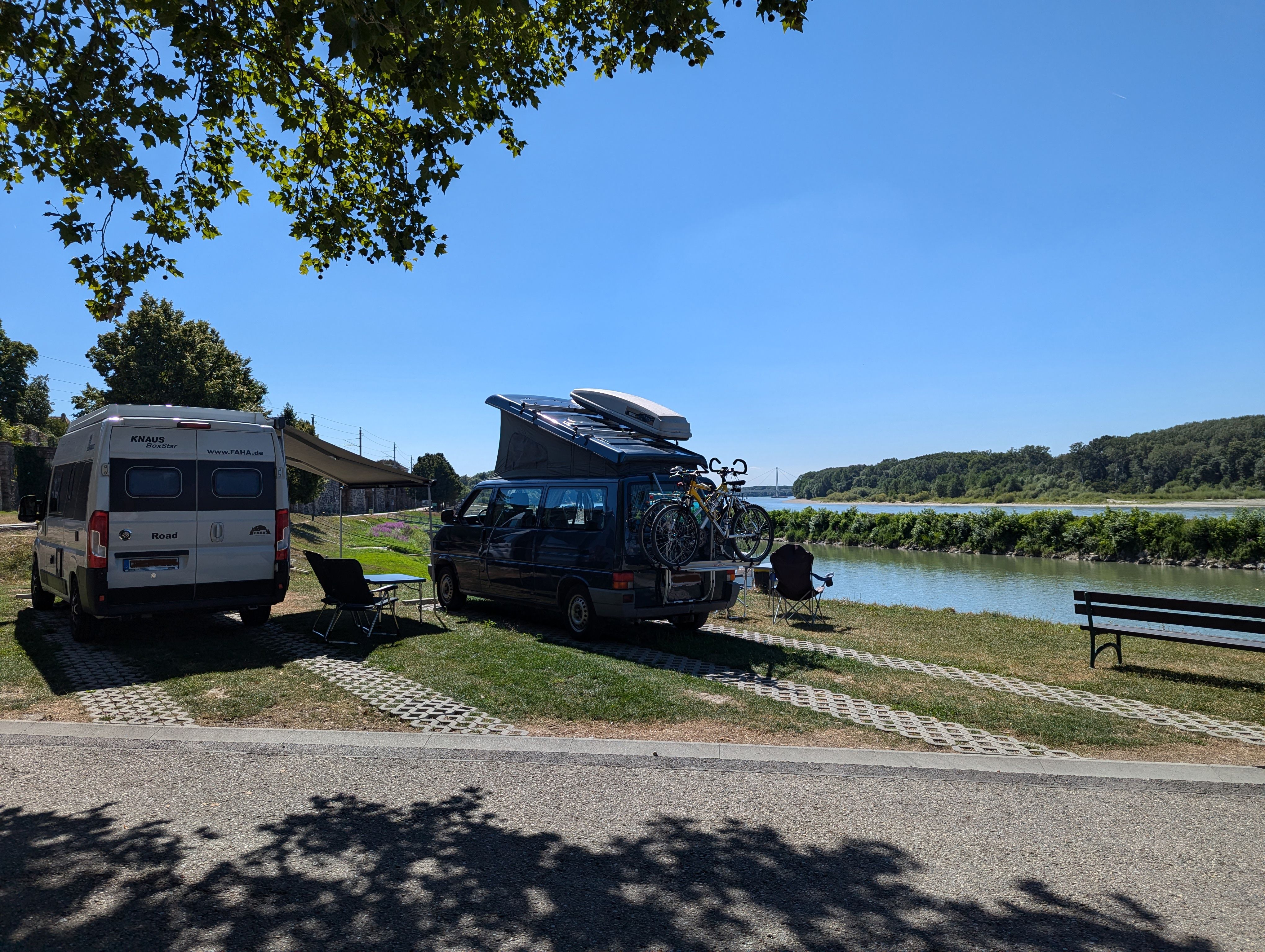 Zwei Wohnmobile auf einem Stellplatz direkt am Donauufer 